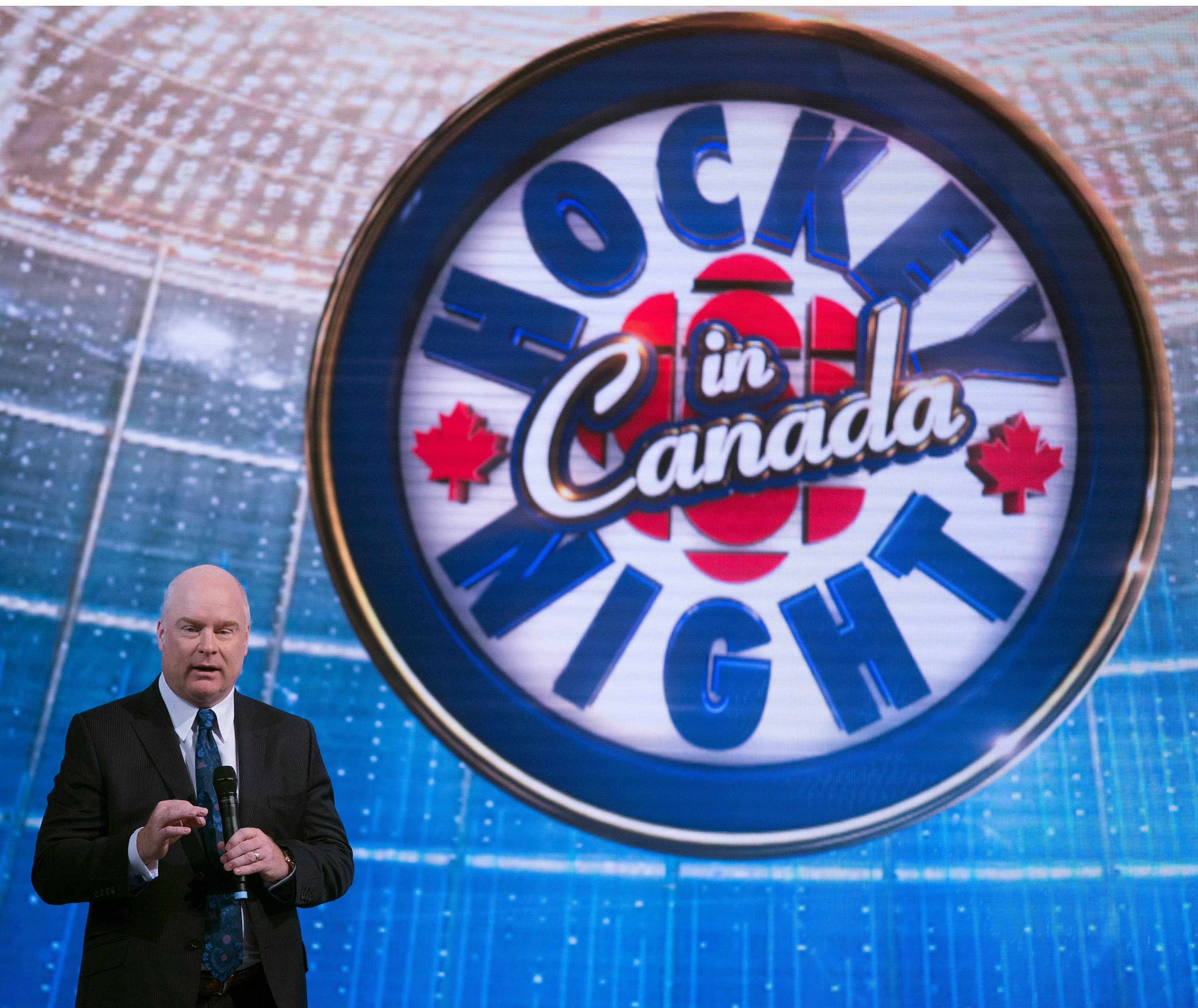 L'ancien président de Sportsnet, Scott Moore, lors du dévoilement d'un nouveau studio de télévision, en 2014. On voit à côté de lui le logo de l'émission « Hockey Night in Canada ».
