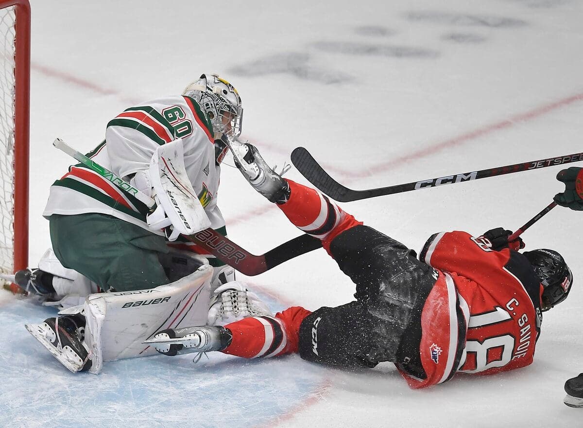 Charles Savoie (18) des Remparts de Québec et Mathis Rousseau (60) des Mooseheads d’Halifax lors de la troisième période de jeu des finales de la LHJMQ au Centre Videotron, le 12 mai 2023.