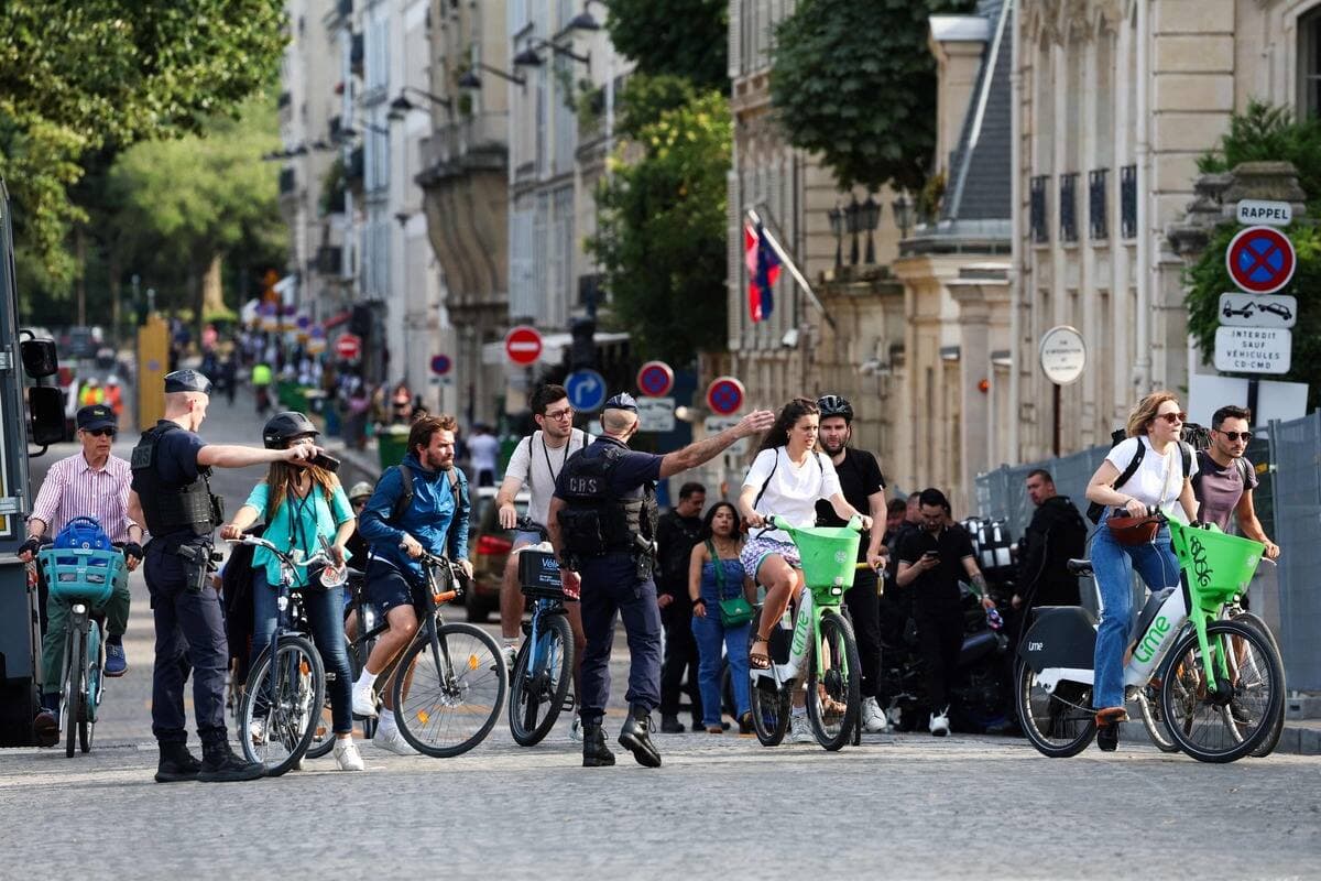 Des policiers montrent à des cyclistes qui étaient sur le point d'entrer dans le «périmètre gris» un autre chemin qu'ils peuvent prendre afin de poursuivre leur route.