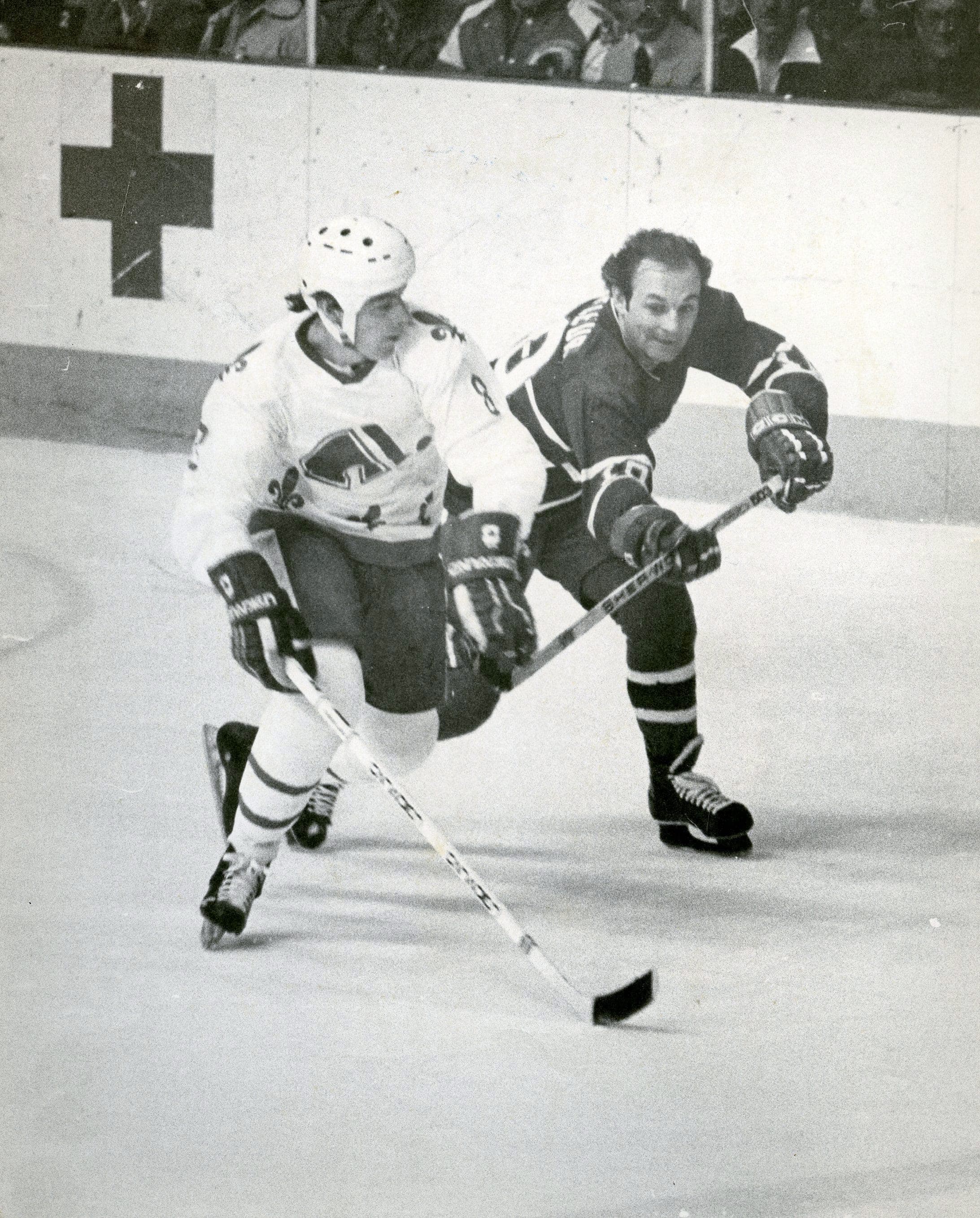 On aperçoit Marc Tardif, des Nordiques, et Guy Lafleur, dans l’uniforme du Canadien.
