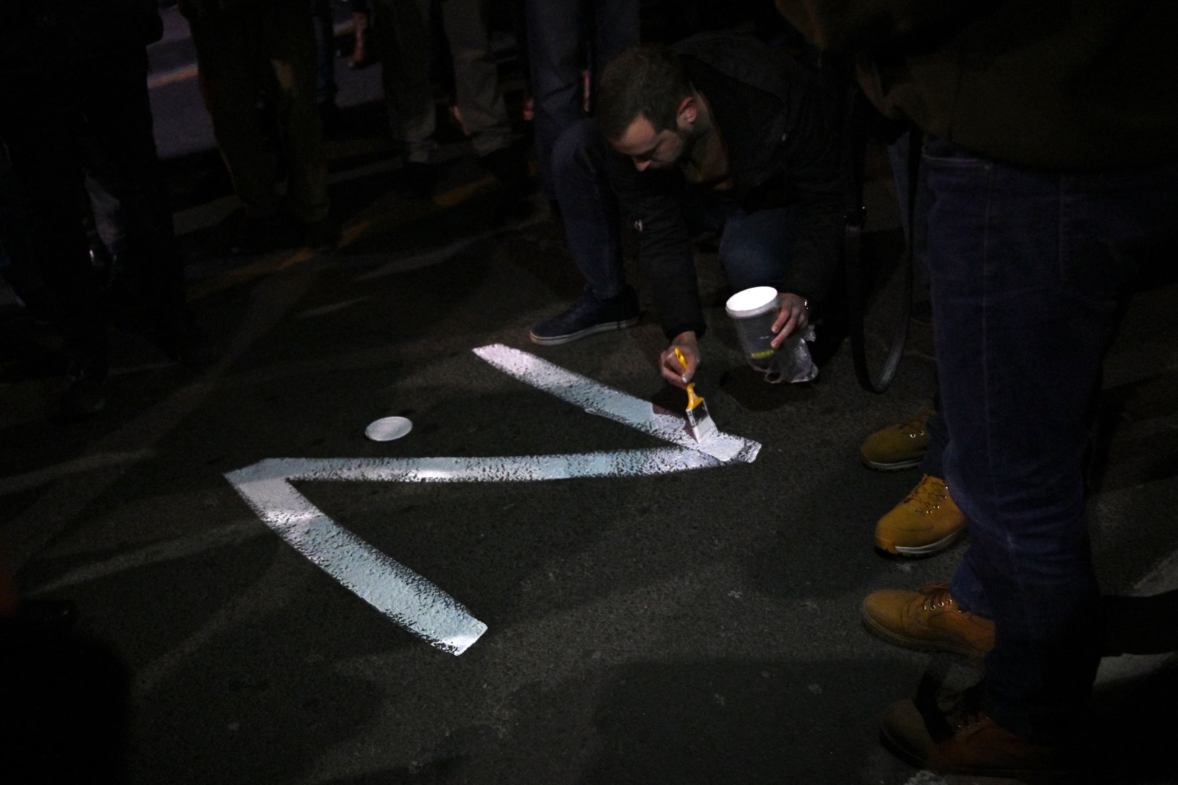 Un manifestant peint la lettre "Z" sur le sol los d'un rassemblement en faveur de l'intervention russe en Ukraine à Belgrade le 4 mars 2022 (AFP - Andrej ISAKOVIC)