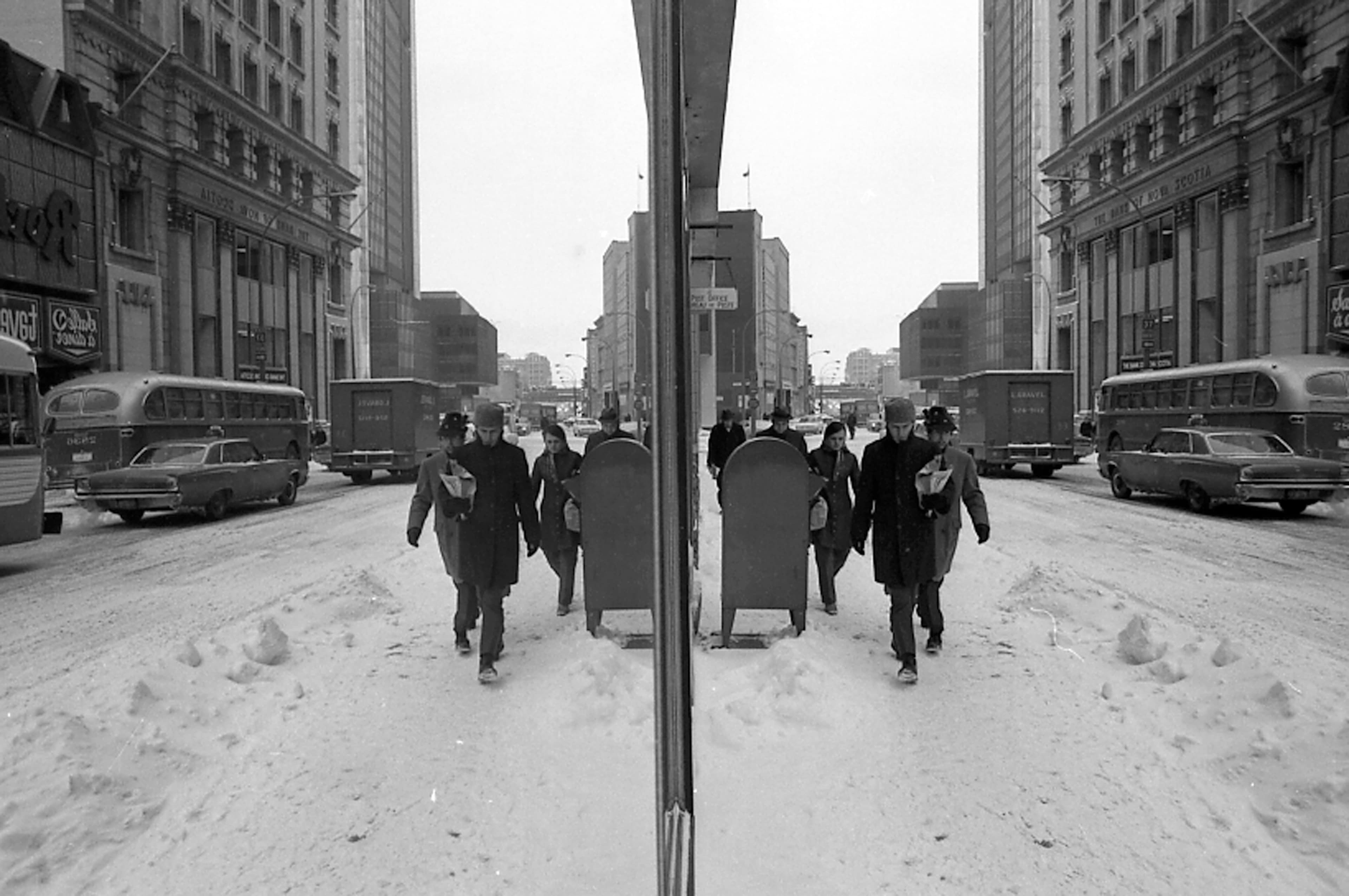 Piétons et automobilistes dans la neige près des rues Saint-Jacques et McGill à Montréal, février 1970.
