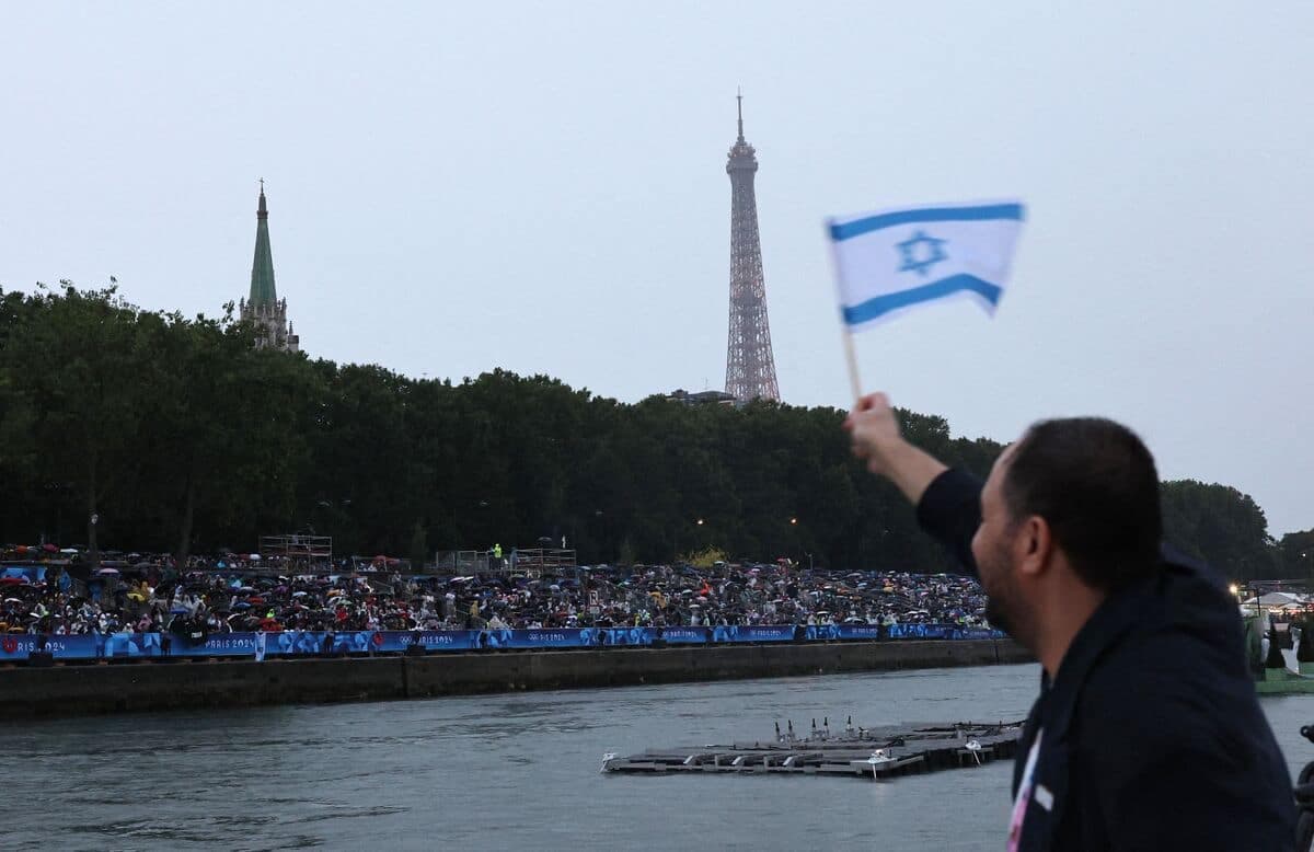Un spectateur salue la délégation israélienne aux Jeux avec un drapeau du pays vendredi dernier, lors de la cérémonie d'ouverture.