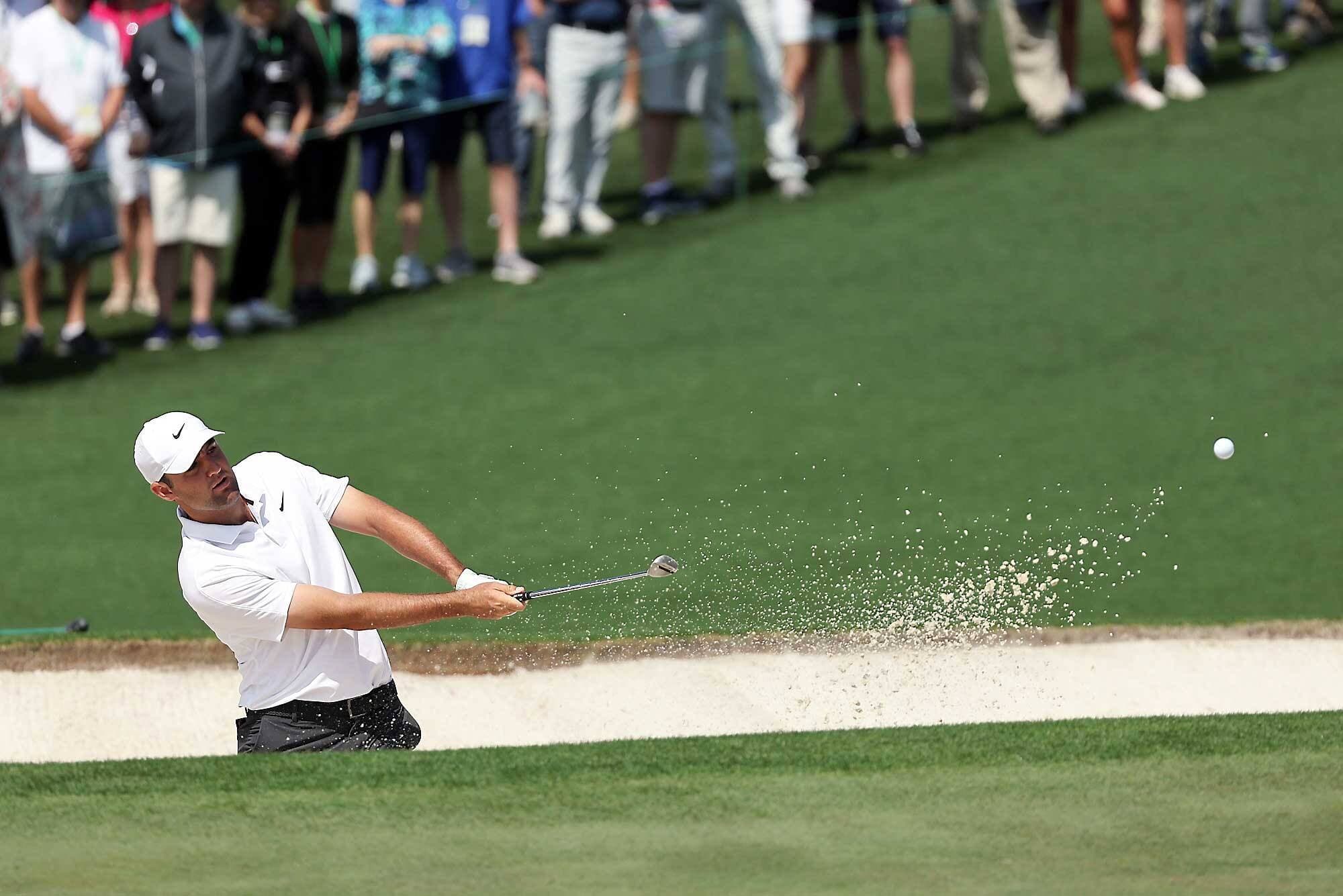 Un des favoris pour remporter le tournoi, Scottie Scheffler a sorti la balle de la trappe de sable en route vers le deuxième trou à la première ronde du Tournoi des Maîtres, jeudi à Augusta.