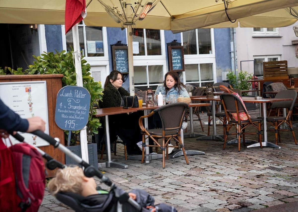 Deux femmes mangent dans un restaurant le 18 mai 2020 à Copenhague. Les voyageurs devront bientôt se munir de passeports vaccinaux pour manger dans les restaurants au Danemark.