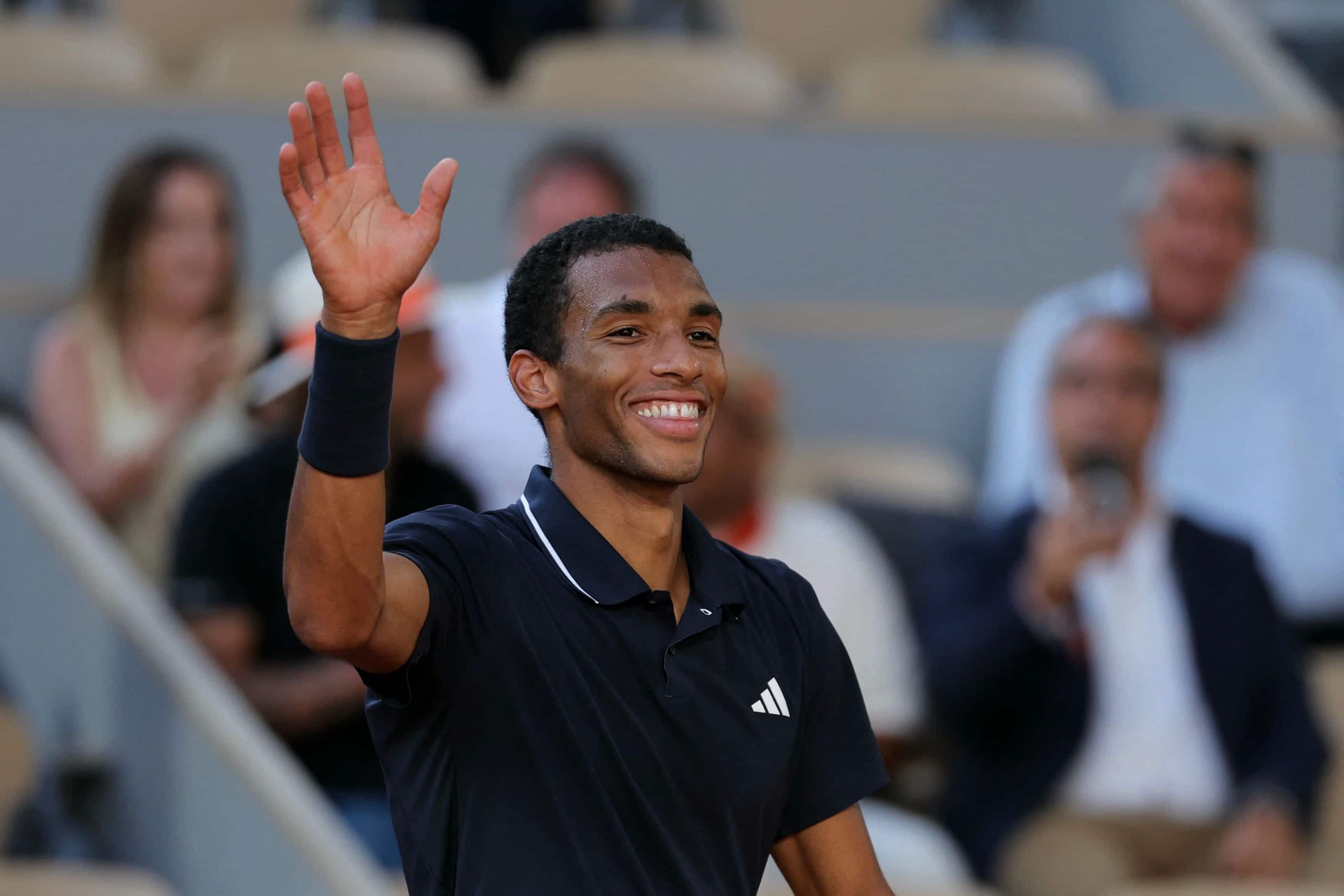 Tout sourire, Félix Auger-Aliassime salue le public après avoir remporté son match de ronde des 16 contre le Chilien Alejandro Tabilo à Roland-Garros, lundi.