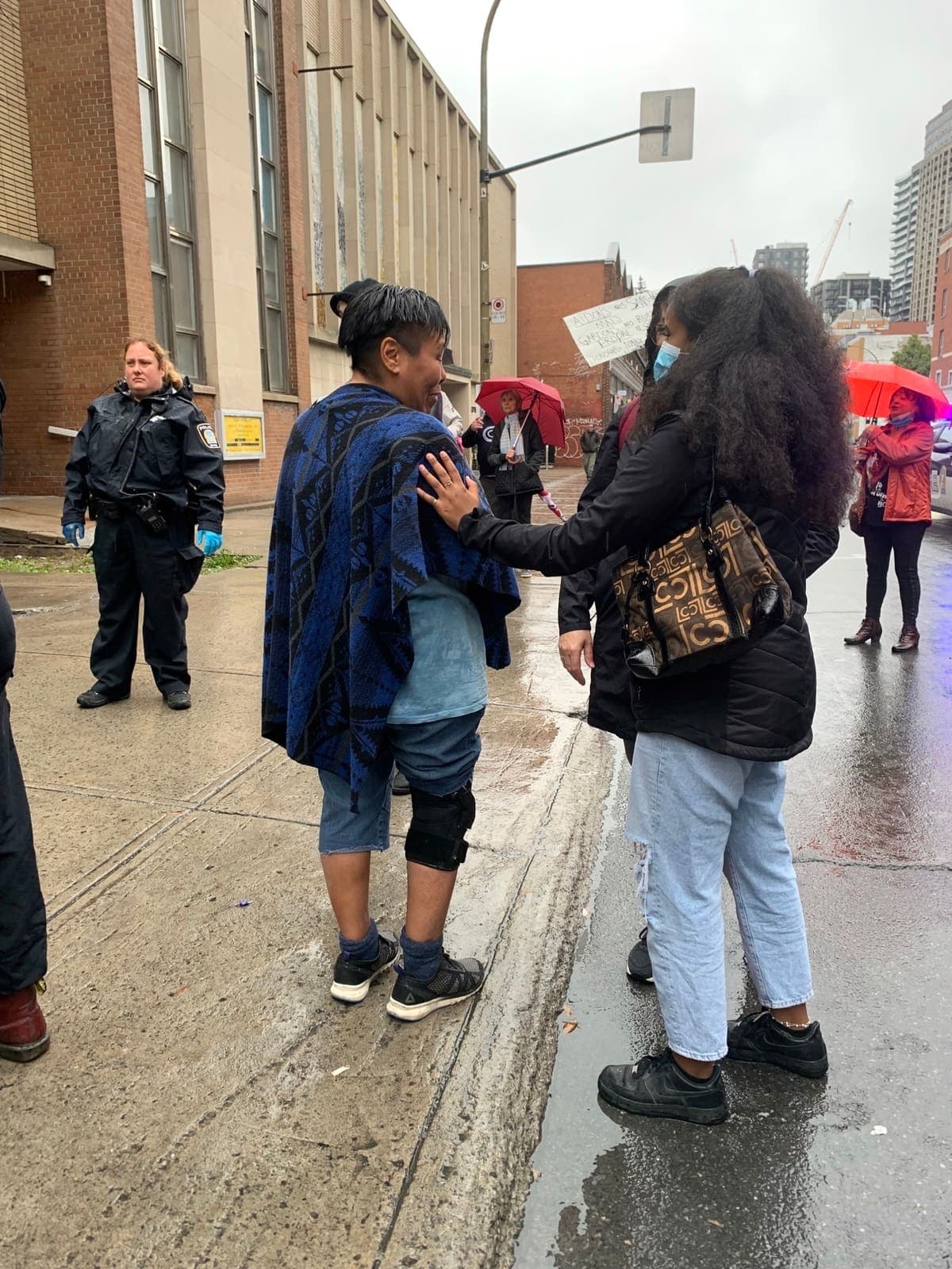 Une centaine de résidents du quartier Milton Parc ont bravé la pluie pour manifester contre la hausse d’itinérance dans leur secteur, qu’il souhaite «revitalisé». ICI : La famille de Chantal s’est arrêtée pour consoler une itinérante qu’ils ont déjà croisé dans la rue pour lui dire qu’ils ne manifestent pas contre eux.LE 2 OCT 2021. Photos Geneviève Abran/24 Heures