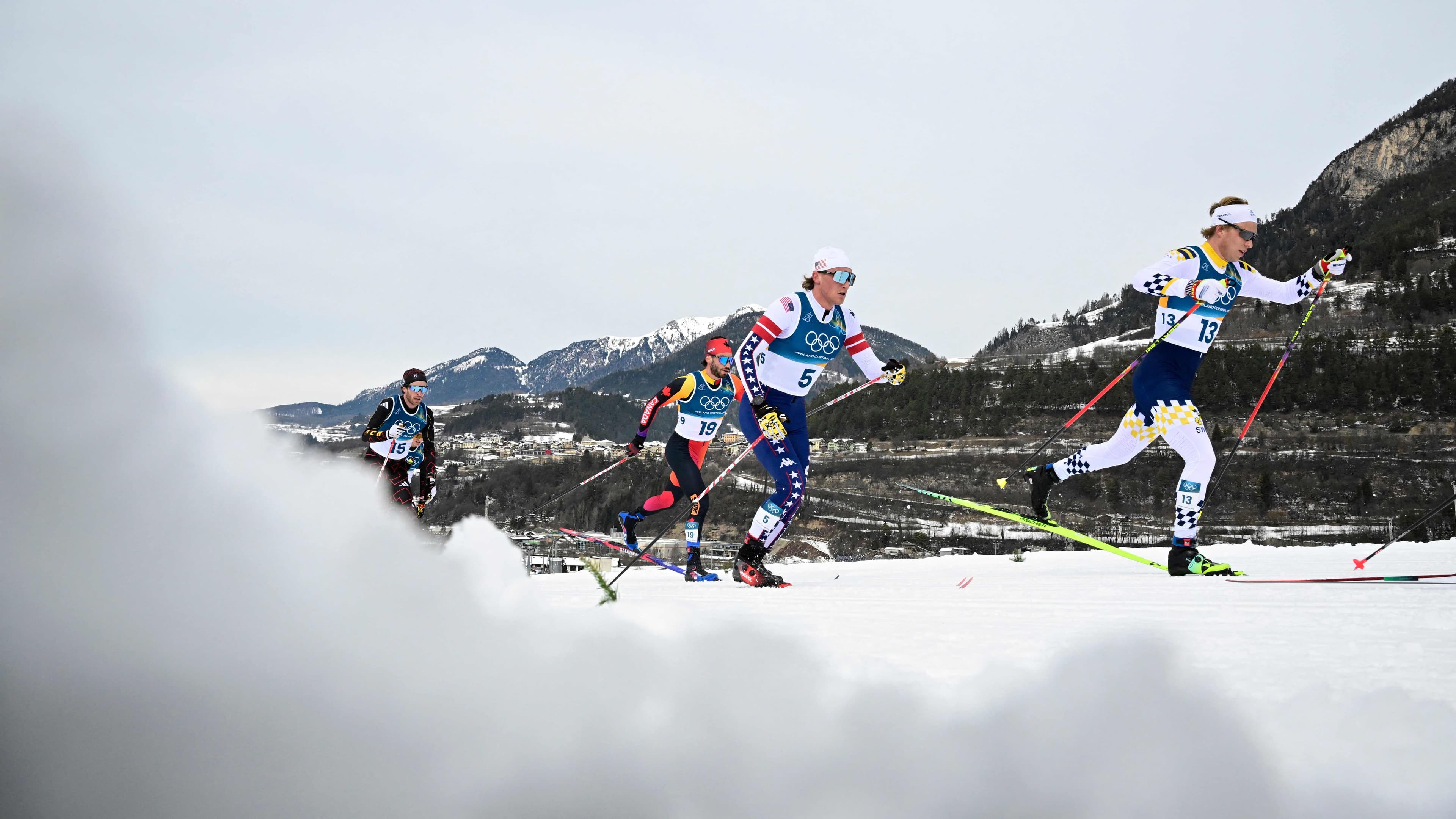 Le Québécois Antoine Cyr, en arrière-plan avec le numéro 19, durant l’épreuve olympique de 50 kilomètres, le 21 février 2026, à Val di Fiemme.