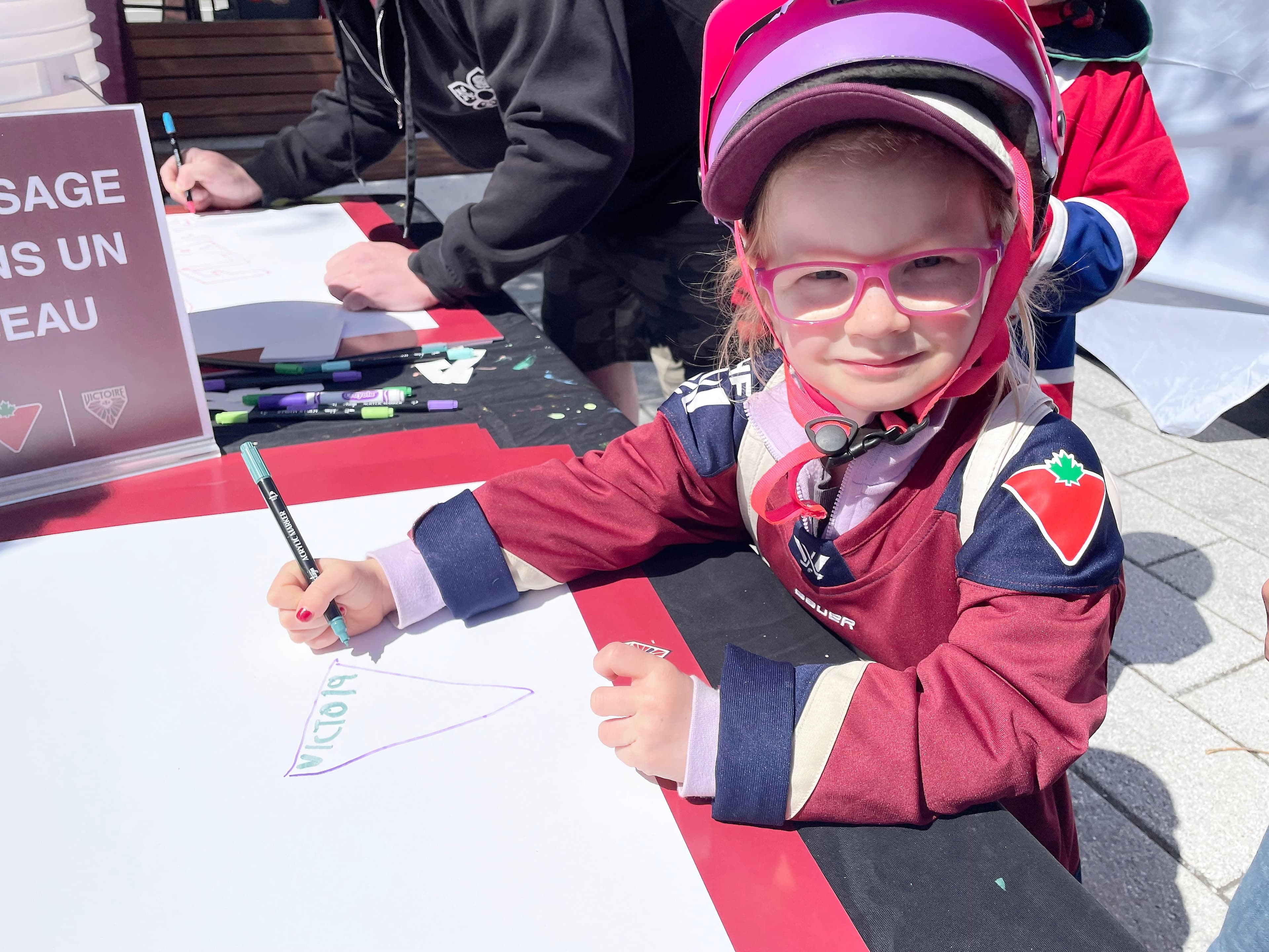 Elizabeth Richards, 4 ans, de Montréal, dessine une affiche pour encourager son équipe favorite, la Victoire.