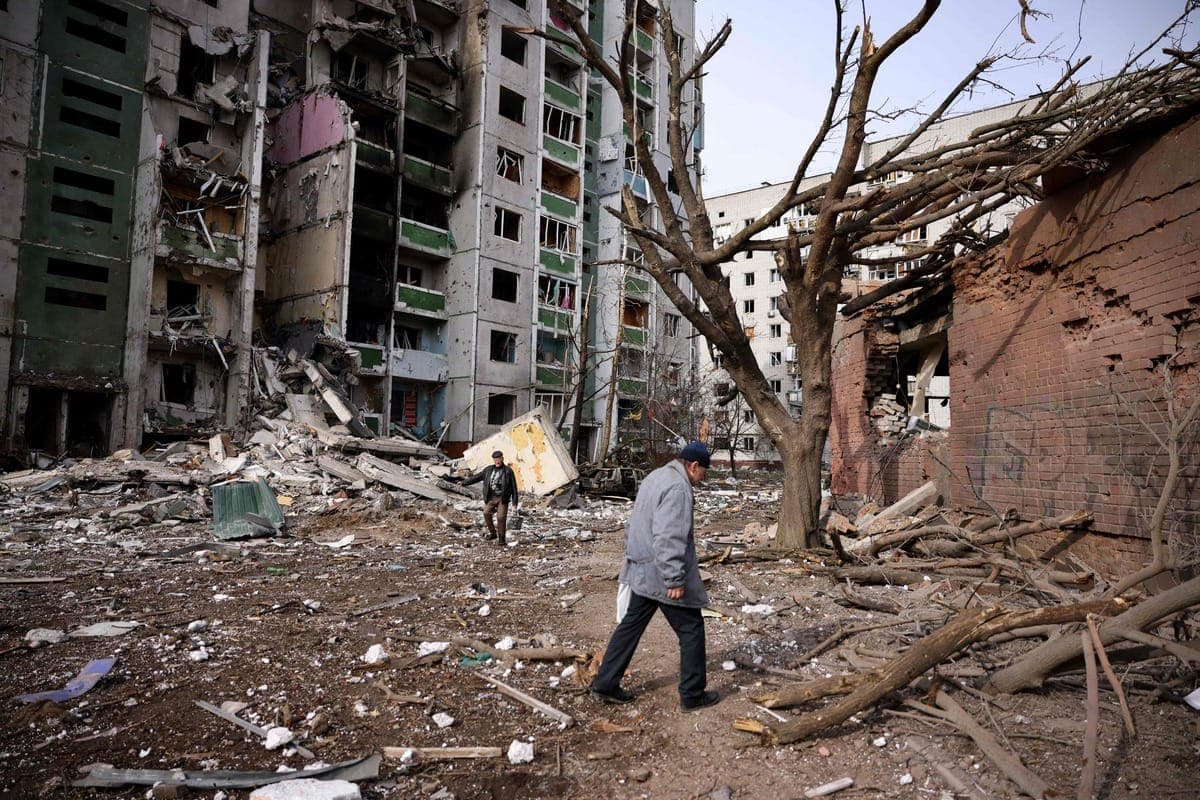 Un homme marche près d'un bâtiment résidentiel en ruines après une attaque russe à Tcherniguiv.