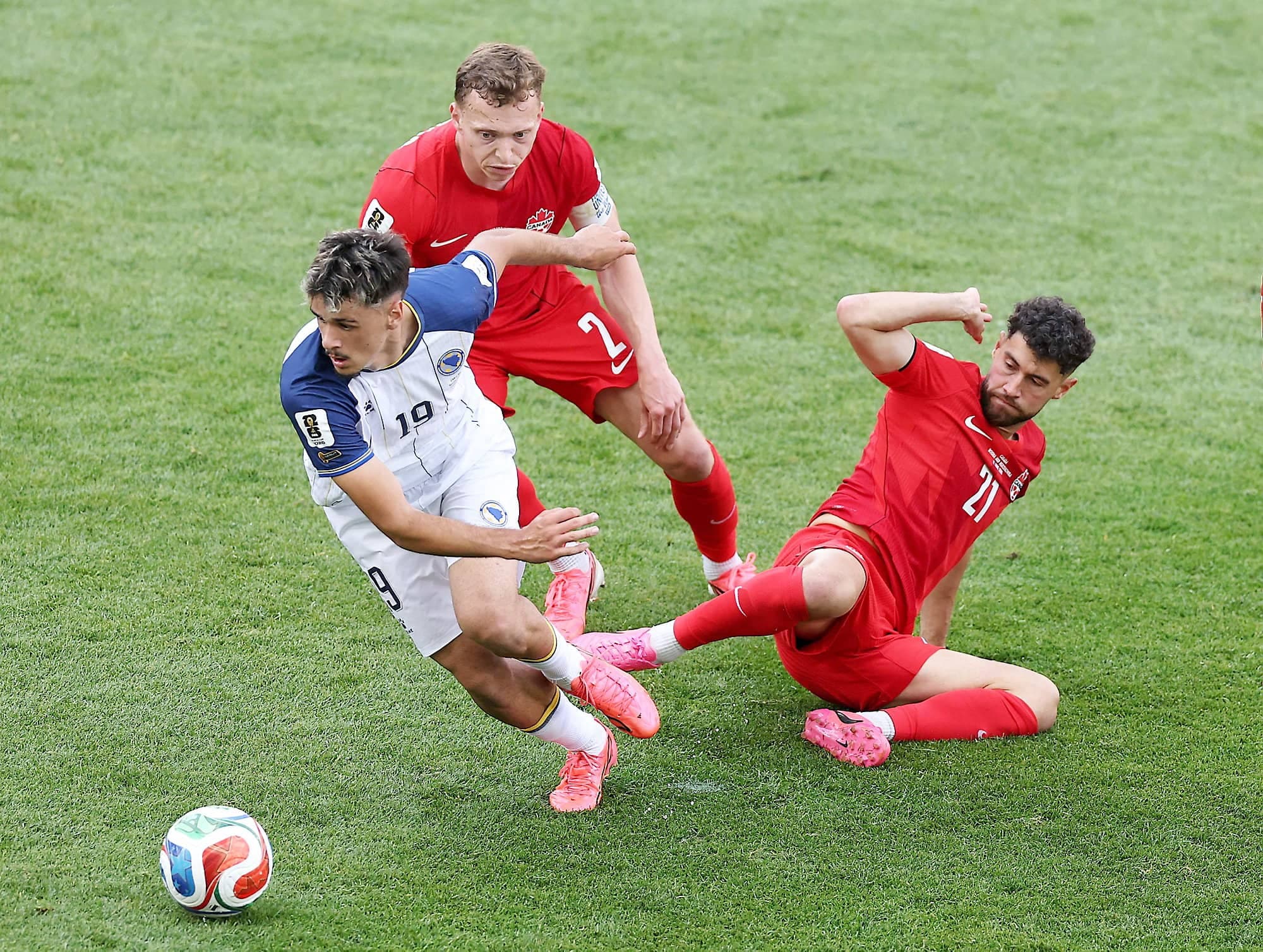 Alistair Johnston (au centre) tente d'aider son coéquipier Jonathan Osorio lors du premier match du Canada à la Coupe du monde de soccer, vendredi à Toronto, face à la Bosnie-Herzégovine.