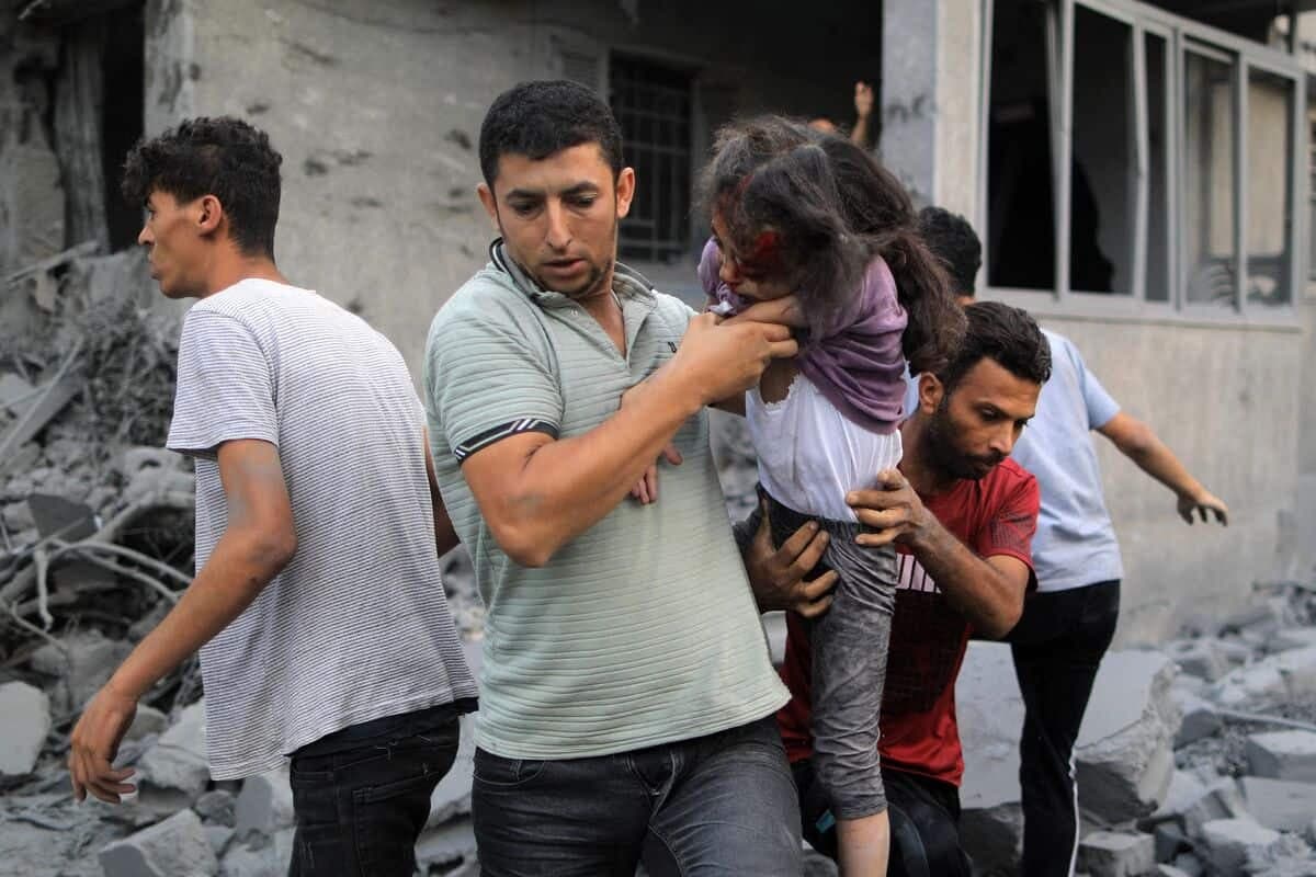 EDITORS NOTE: Graphic content / A Palestinian man rescues a girl from the rubble of a building following an Israeli strike, in Khan Yunis in the southern Gaza Strip on October 14, 2023, as fighting between Israel and the Hamas movement continues for the eighth consecutive day. Thousands of people, both Israeli and Palestinians have died since October 7, 2023, after Palestinian Hamas militants based in the Gaza Strip, entered southern Israel in a surprise attack leading Israel to declare war on Hamas in Gaza on October 8. (Photo by YASSER QUDIH / AFP)