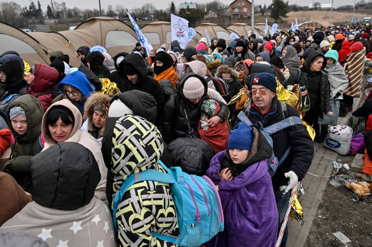 Des réfugiés ukrainiens attendent au froid d'être transférés dans un train.