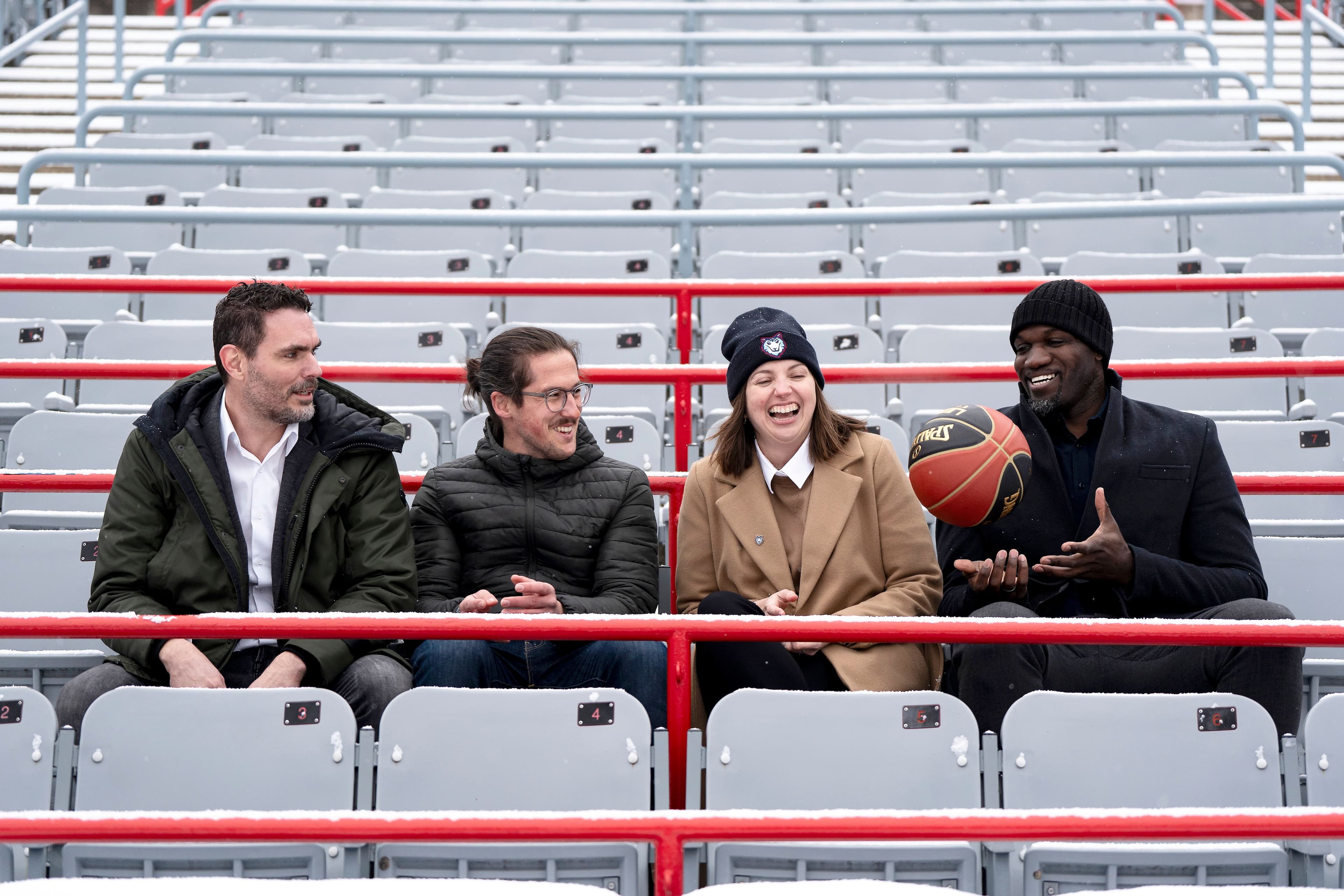 Jo-Annie Charbonneau, présidente de l'équipe de basketball de l'Alliance de Montréal, est entournée des copropriétaires, Ian-Philip Paul-Hus, Léo Bouisson et Joel Anthony, aussi directeur général, dans les estrades enneigées du stade IGA, lundi.