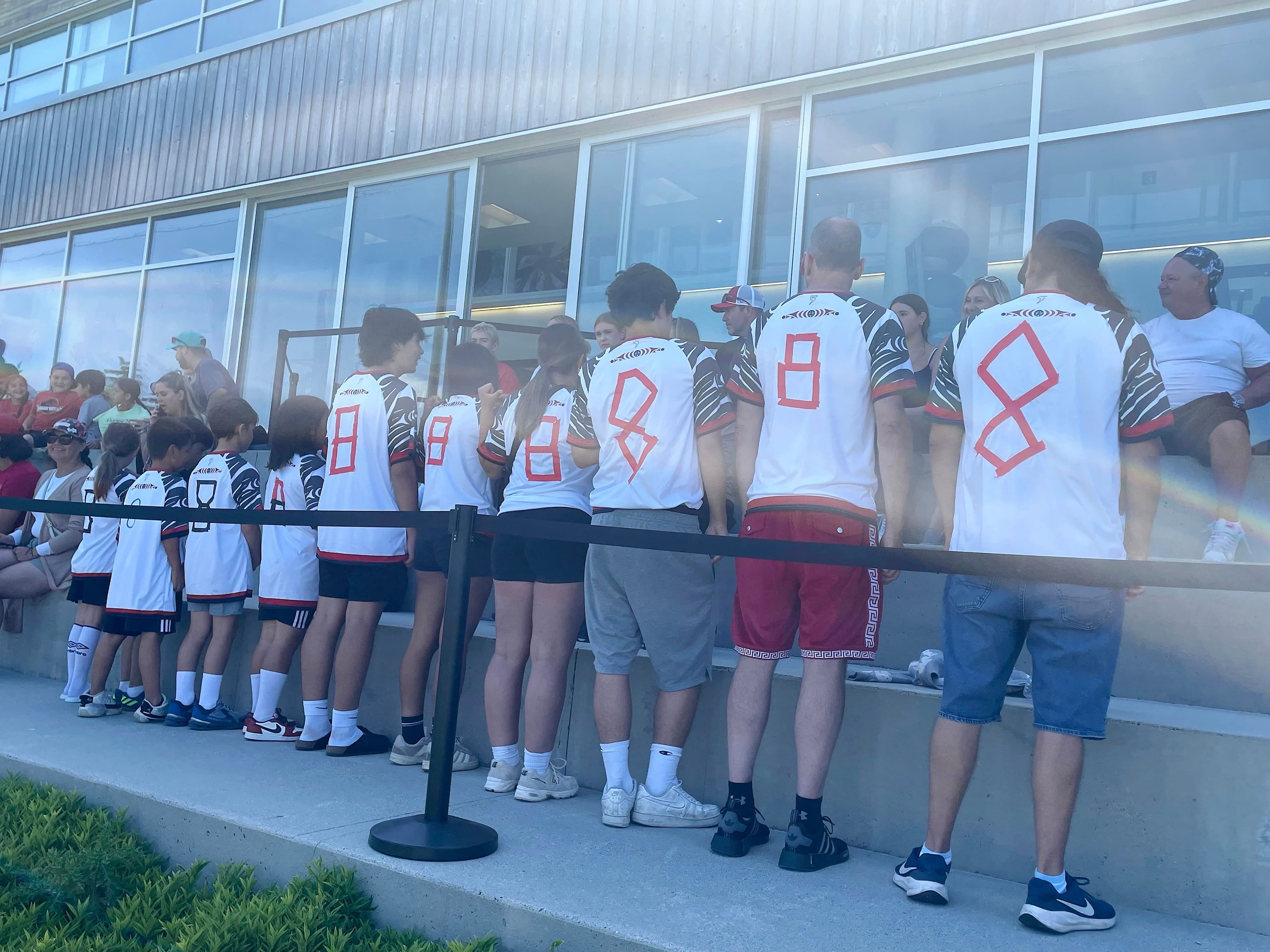 Des élèves de la nation Tsleil-Waututh, invités à assister à l’entraînement de la formation canadienne à Vancouver, dimanche, ont ajouté le numéro 8 d'Ismaël Koné à l’aide de ruban adhésif rouge et noir au dos de leur chandail blanc du Canada.