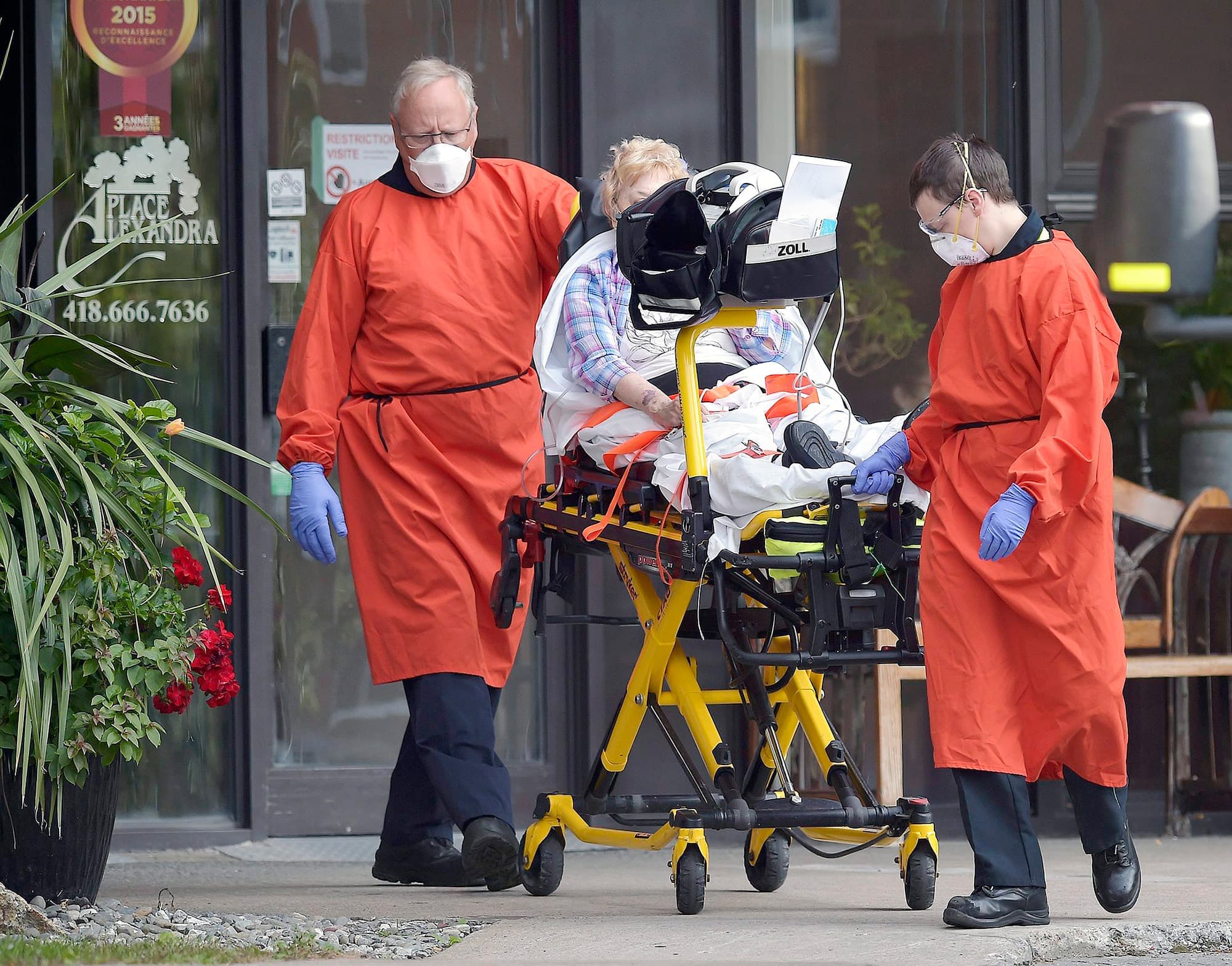 Des ambulanciers emmènent une aînée à l’hôpital à la suite d’une éclosion de COVID-19 à la résidence pour personnes âgées Place Alexandra.