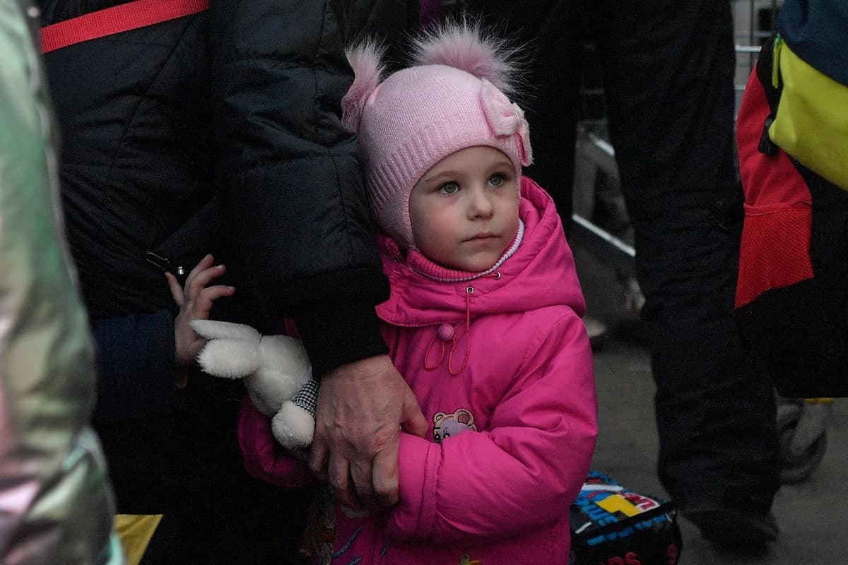 Une jeune réfugiée ukrainienne tient la main de sa grand-mère après avoir traversé la frontière avec la Pologne.