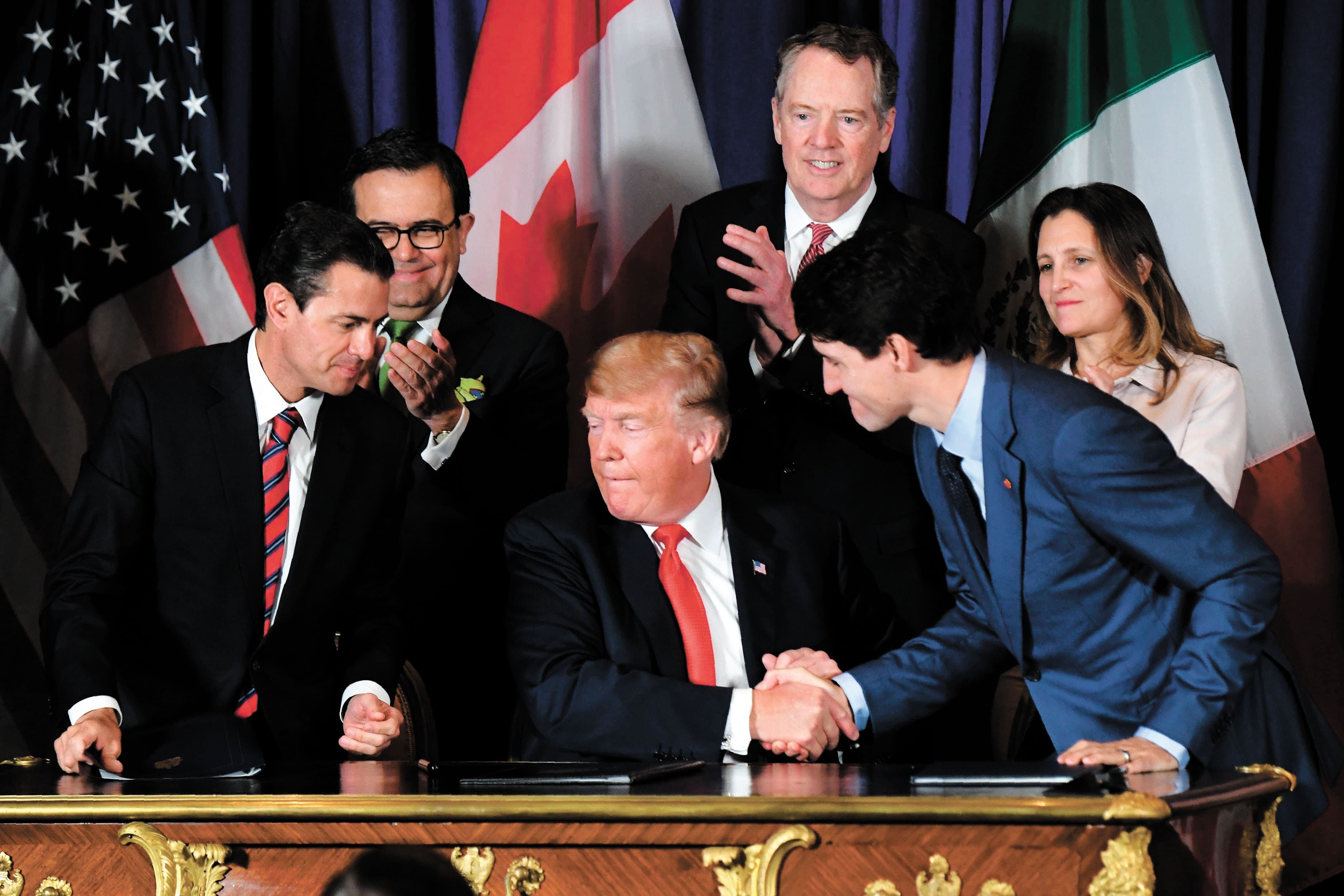 Le président américain Donald Trump (au centre) serre la main du premier ministre canadien Justin Trudeau, sous le regard du président mexicain d’alors Enrique Pena Nieto, en novembre 2018, en Argentine, lors de la cérémonie de signature de l’Accord Canada-États-Unis-Mexique.