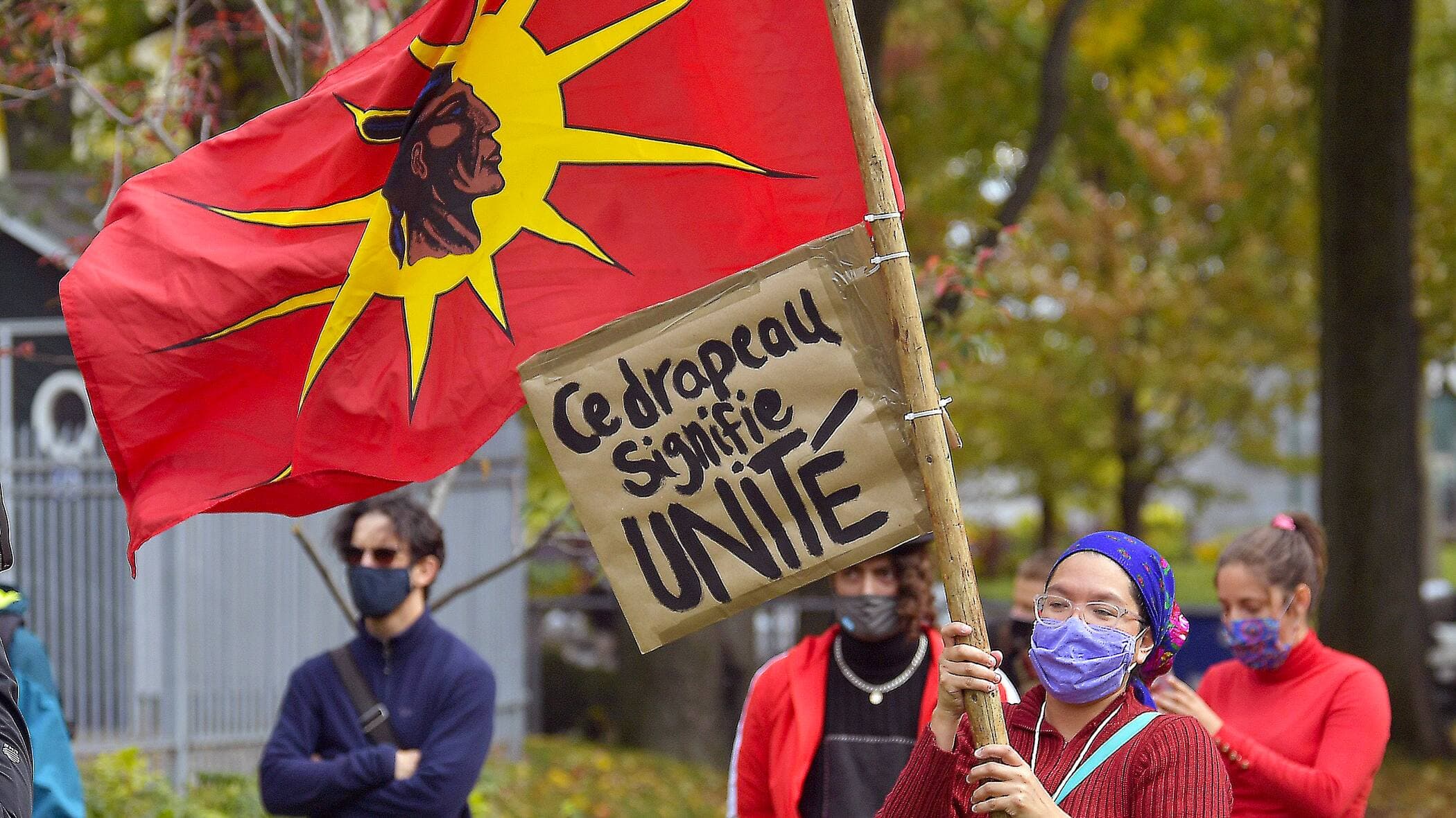 Une manifestante à Québec avec le drapeau des Warriors mohawks.
