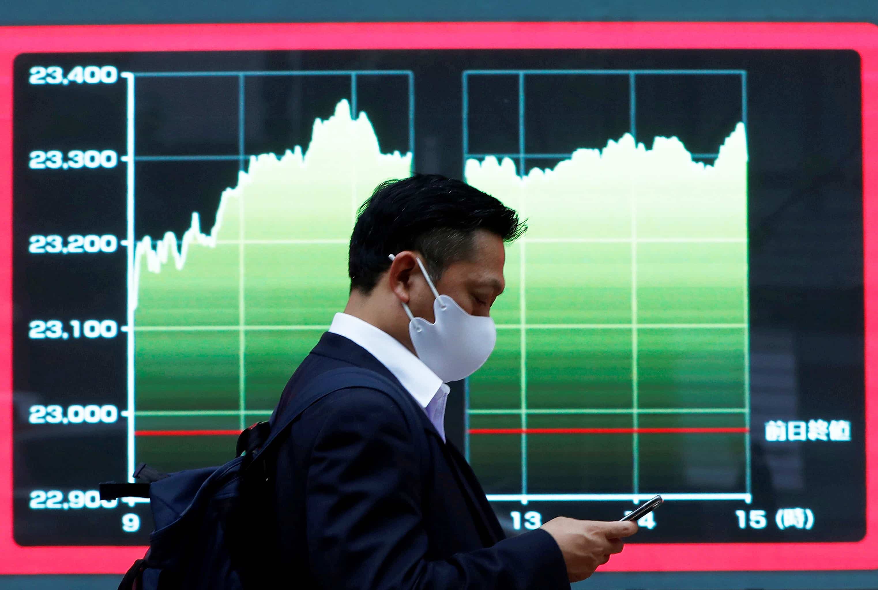 Un passant, dans le quartier de la Bourse, à Tokyo. Les marchés financiers asiatiques et européens ont, comme les Bourses nord-américaines, connu une bonne journée, hier.
