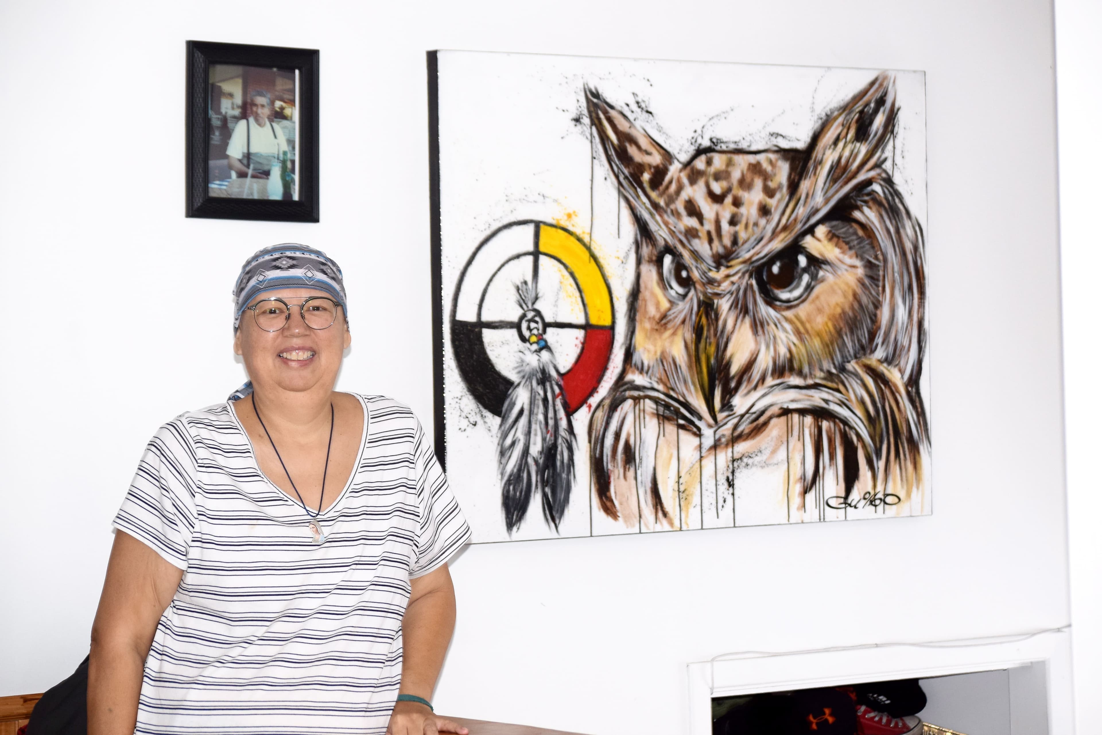 Claudia Newashish pose devant une toile que la communauté lui a remise pour lui donner espoir dans sa bataille contre le cancer.