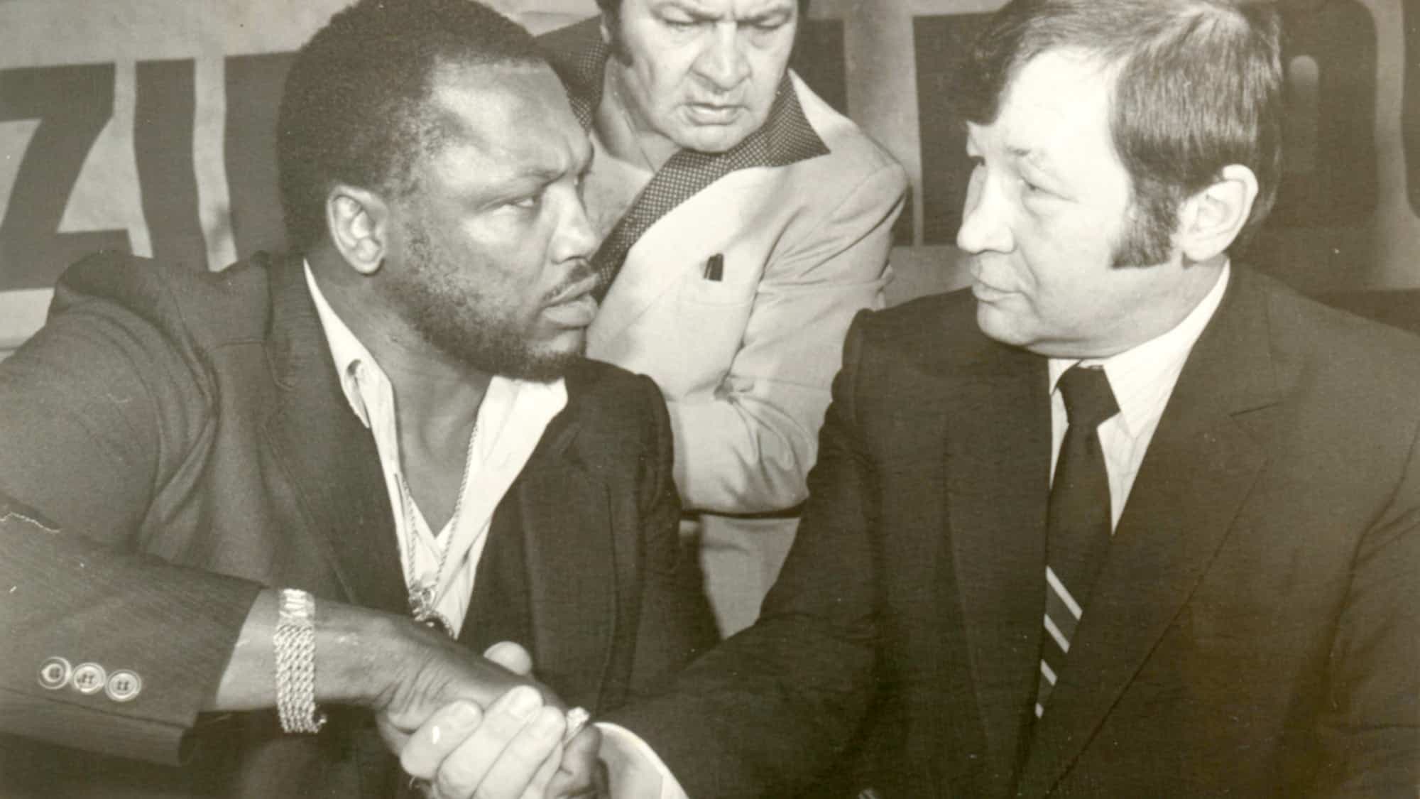 Prise en 1985, on le voit serrer la main à Joe Frazier sous le regard de Régis Lévesque pour un combat qui n’a jamais eu lieu.