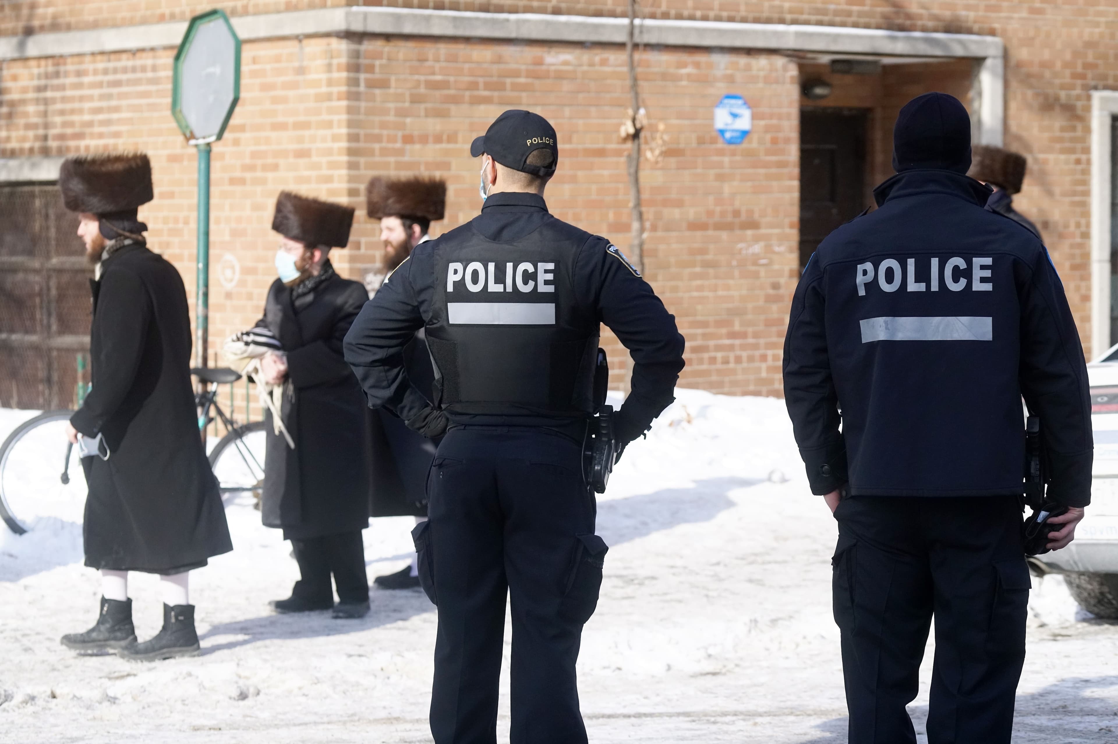 Deux policiers surveillent les abords de la synagogue au coin Durocher et Lajoie à Montréal.