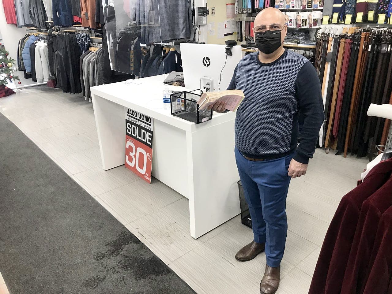 Jack Hallack, de la boutique Jaco Uomo, montre sa pile de commandes pour des mariages qui ont été annulés ou reportés.