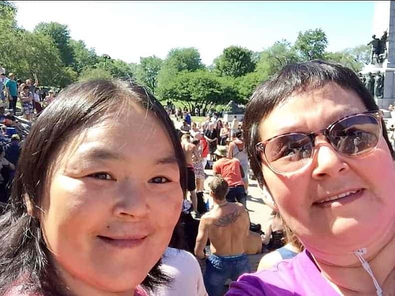 Une des victimes, Kataluk Paningaya (à gauche), et sa sœur Maggie Naluiyuk profitent d’une belle journée sur le mont Royal pour écouter les joueurs de tam-tams.