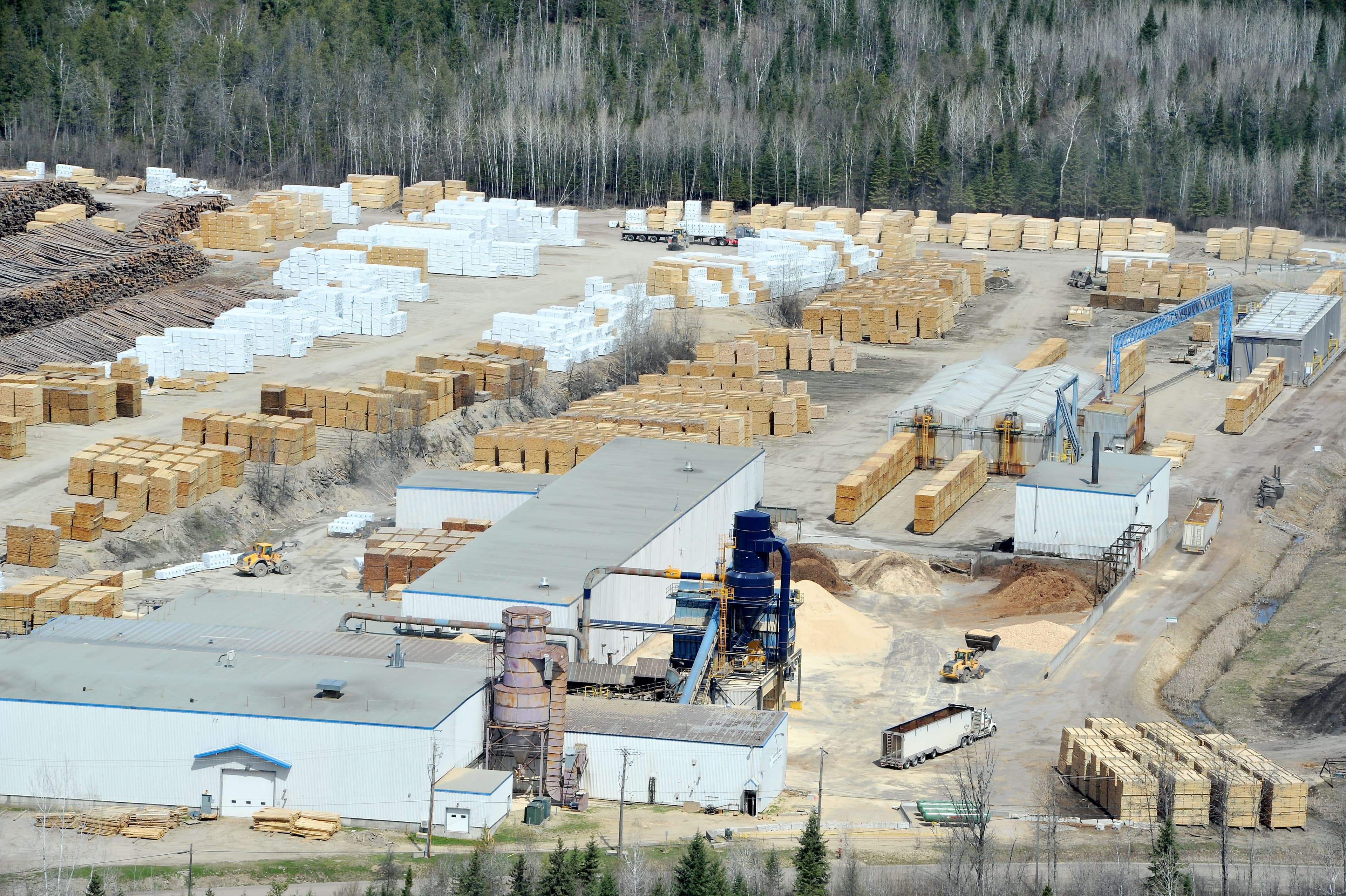 Du haut des airs, à bord de l’hélicoptère TVA, le niveau d’activité élevé des scieries paraît incontestable. Tandis que les uns suggèrent une pénurie de bois de construction, les cours des grands de l’industrie du sciage débordent, comme le montre ci-haut celle de Produits forestiers Résolu, à Maniwaki, dans la région de l’Outaouais.