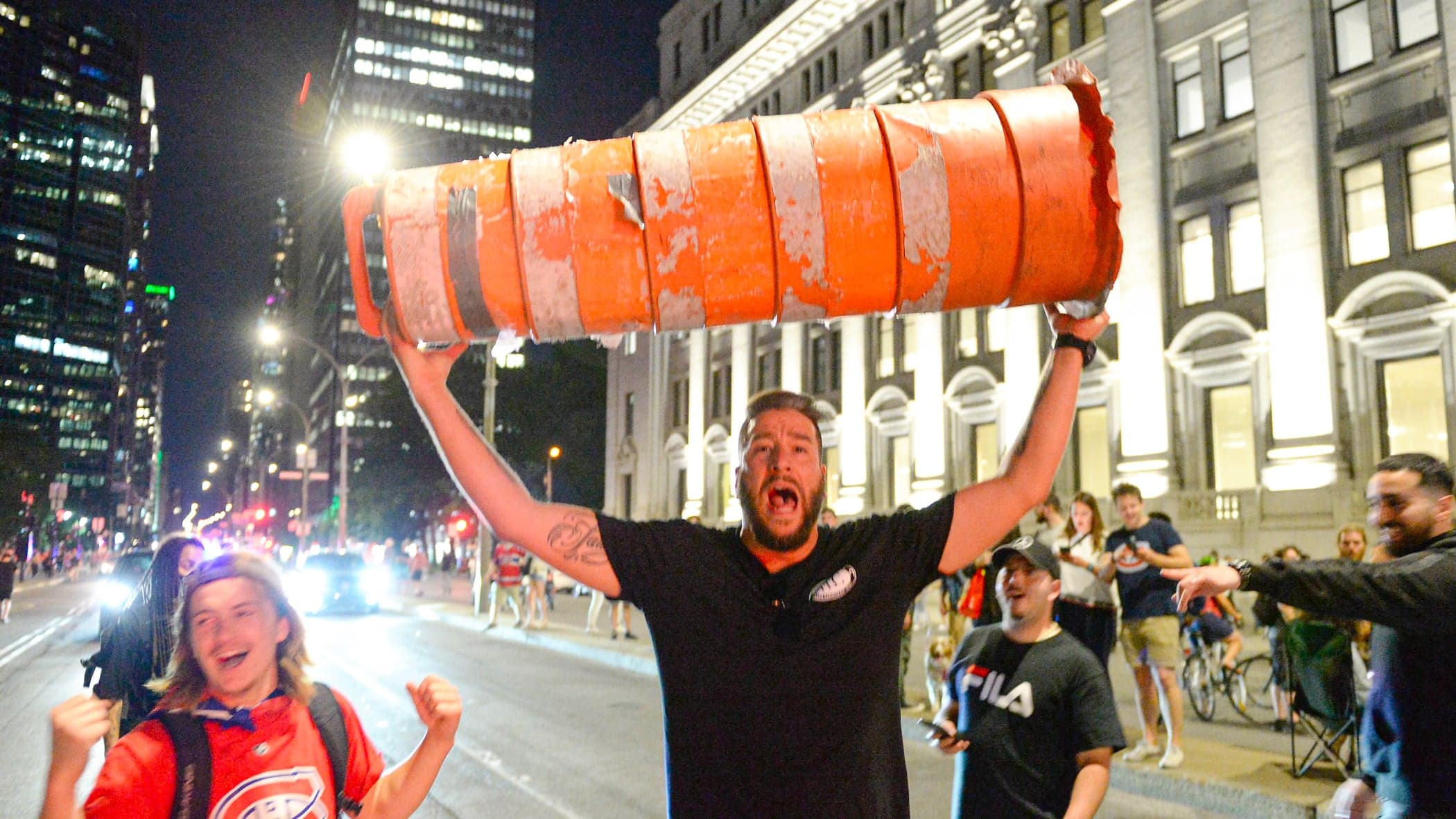 Un partisan tient une réplique très montréalaise de la coupe Stanley, après la victoire.