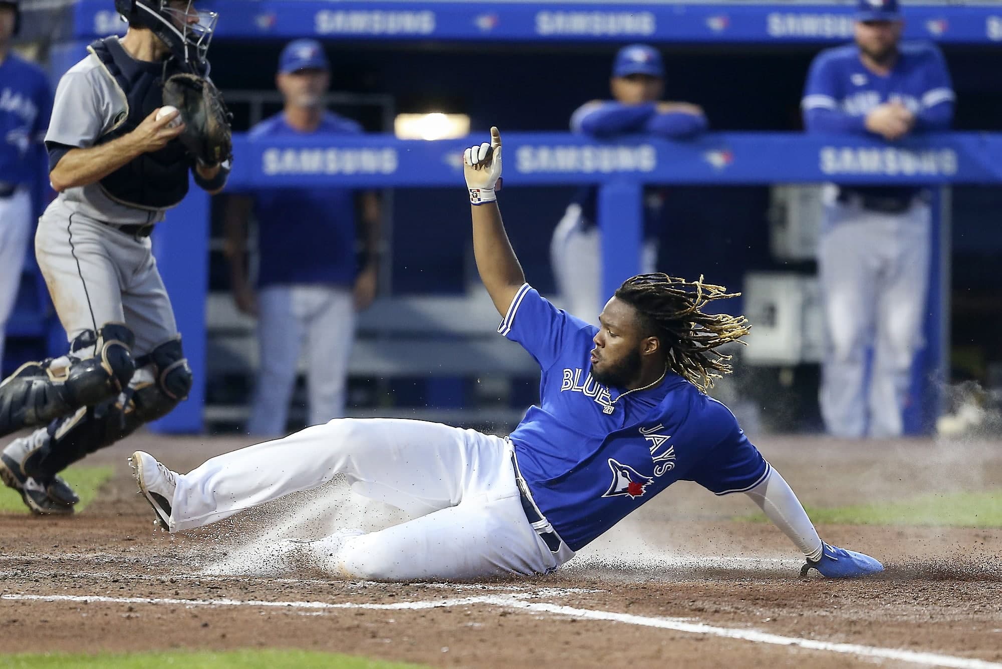 Vladimir Guerrero Jr glisse au marbre hier sur un ballon sacrifice de Cavan Biggio.
