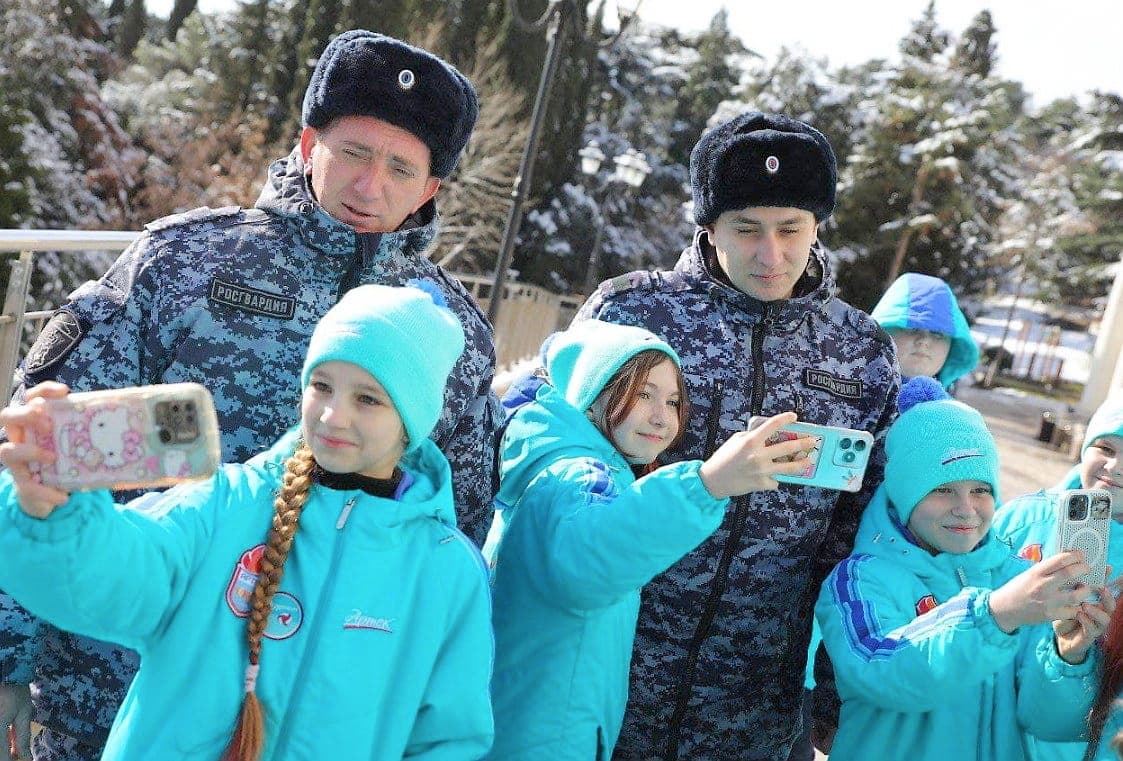 De jeunes participants au camp Artek prennent un égoportrait avec des membres de la garde nationale côtière de la Russie qui leur ont rendu visite.