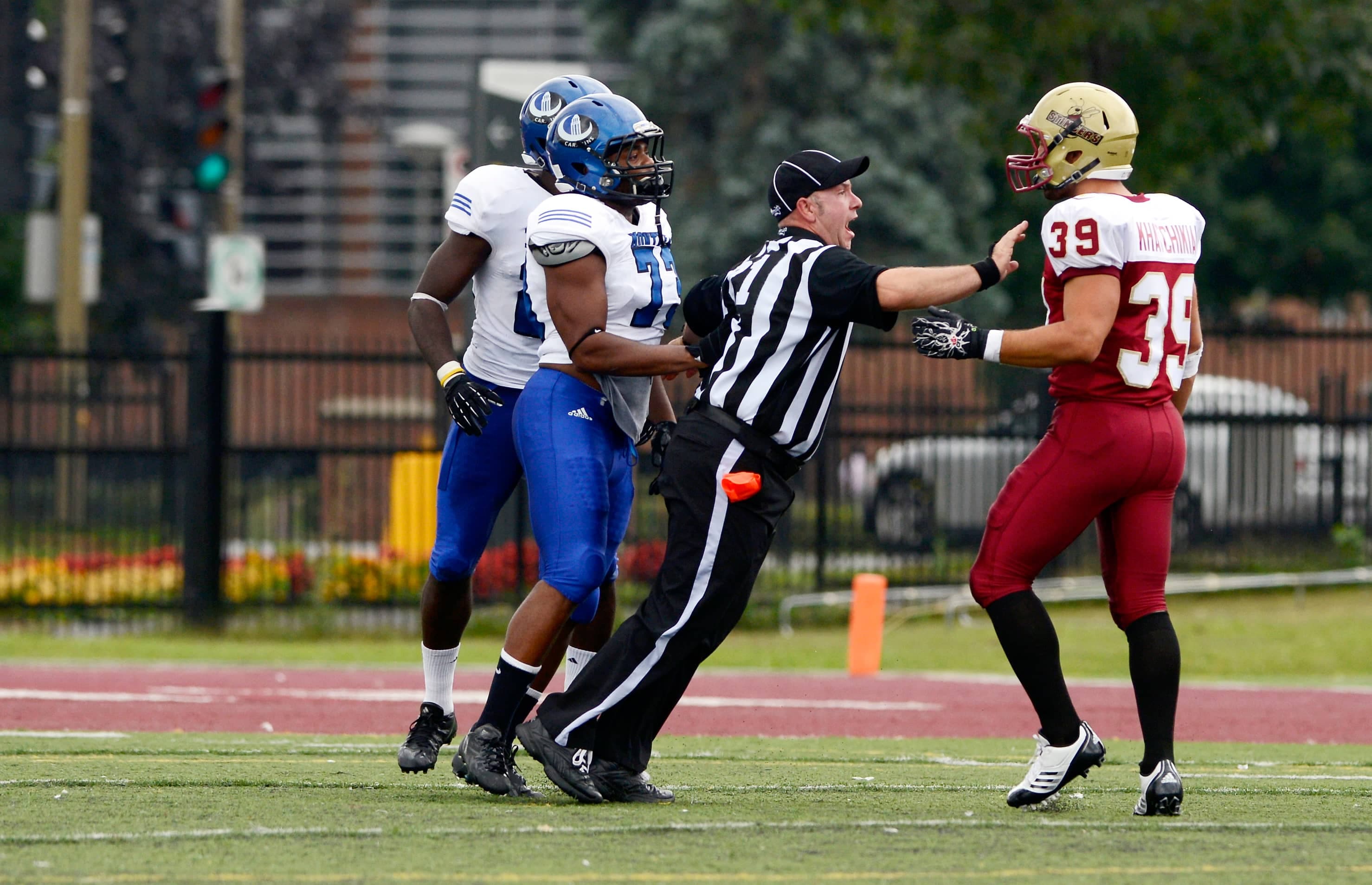 Un arbitre s’interpose entre un joueur des Stingers de Concordia et un autre des Carabins de l’Université de Montréal, en 2013.