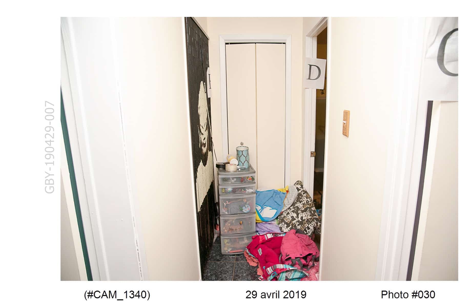Ci-dessus, le corridor menant à la chambre de la victime, où l'on voit le rideau de billes à gauche et un rouleau de ruban adhésif au centre.
