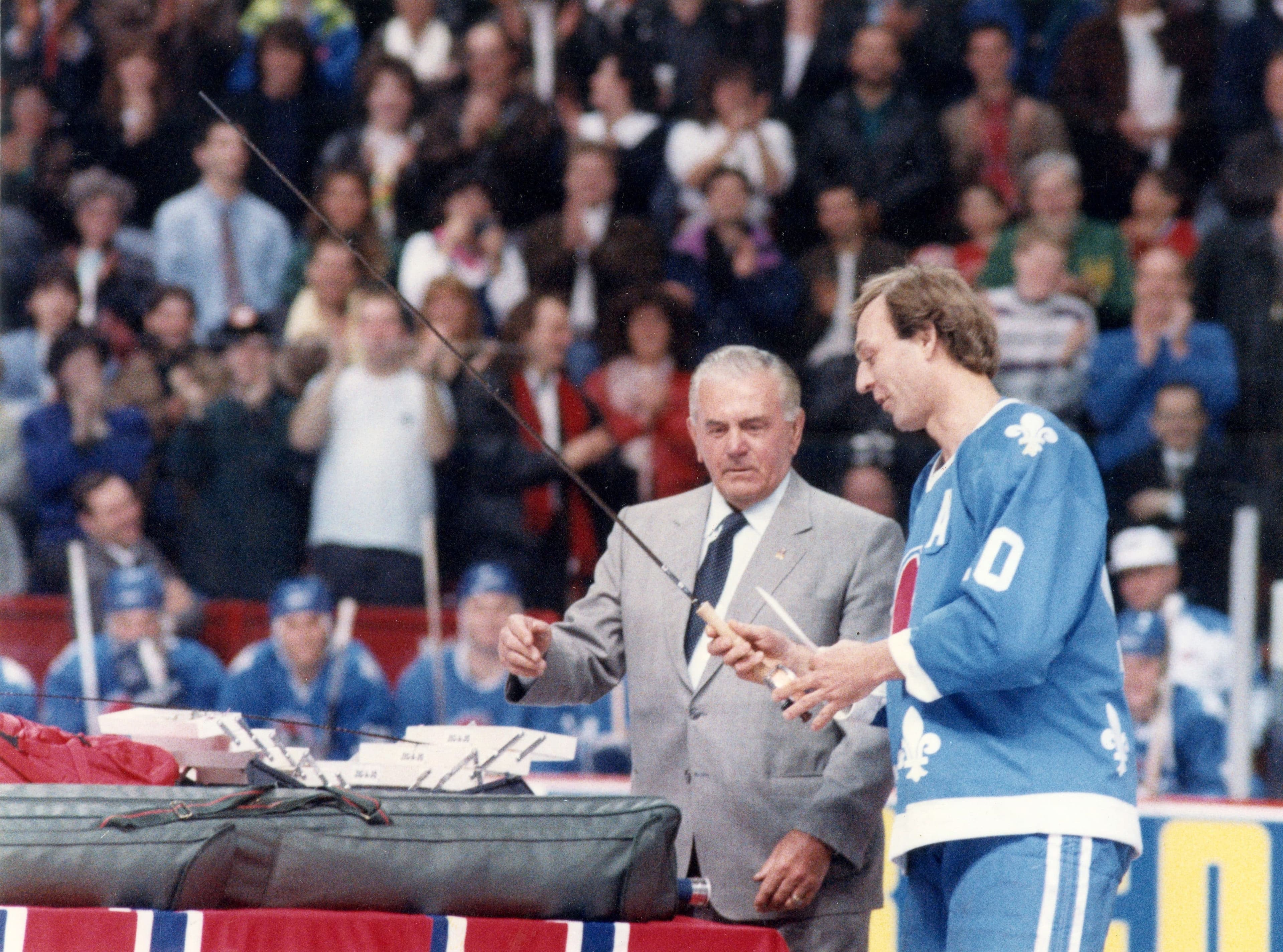 Guy Lafleur reçoit un attirail de pêche des mains de Maurice Richard, qui était lui-même fabricant de mouches à pêche.