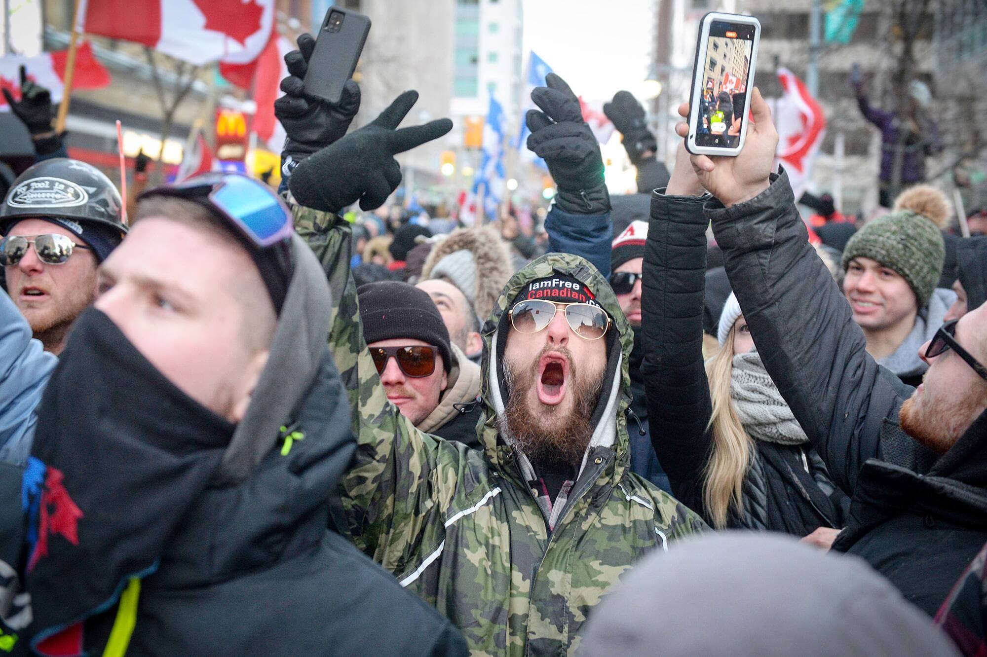 Des manifestants, samedi à Ottawa, avec leur téléphone au bout des doigts.