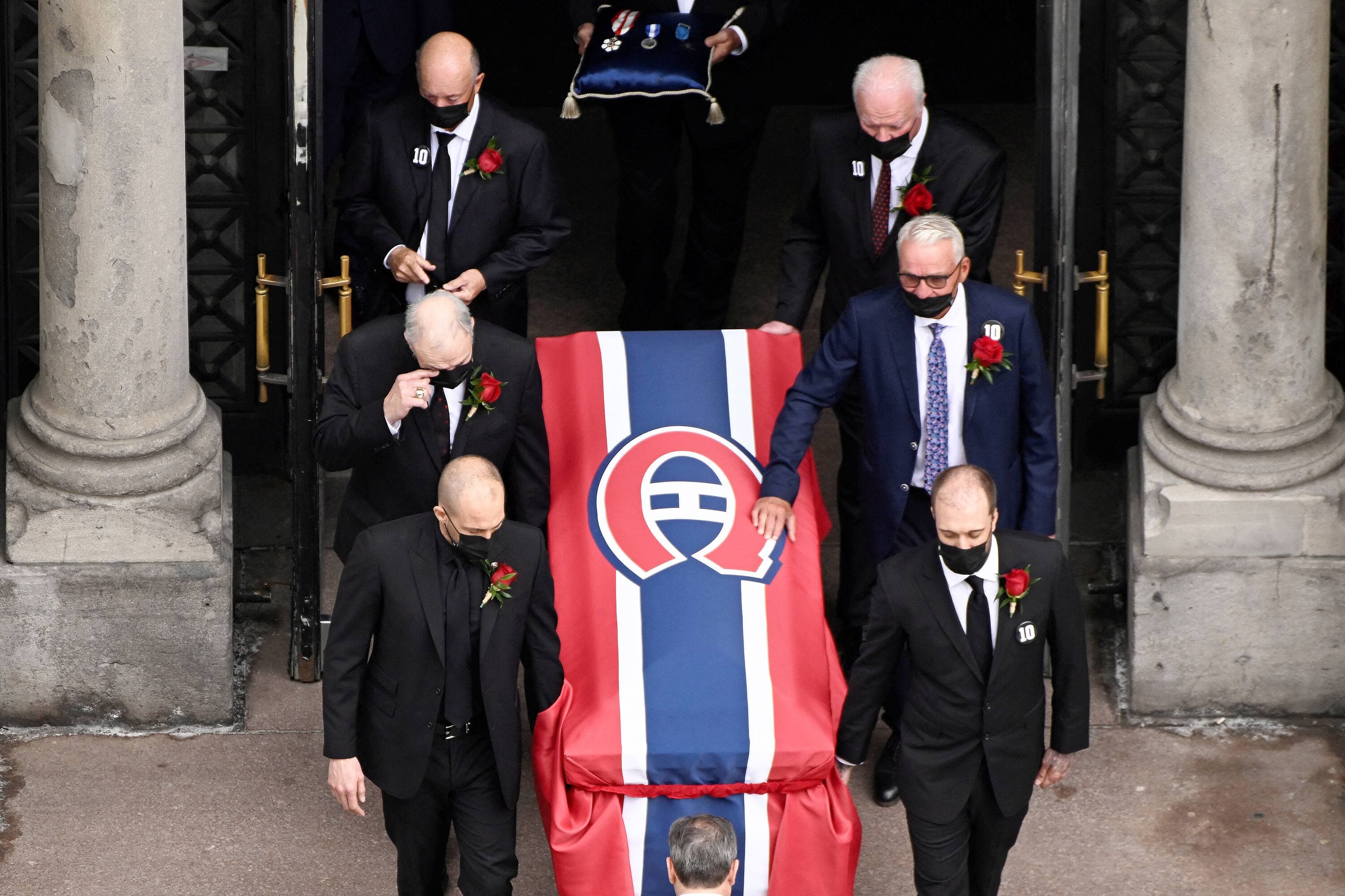La dépouille de Guy Lafleur à sa sortie de la cathédrale, portée par ses fils Martin et Mark Lafleur en avant-plan, suivis de Guy Lapointe et Mario Tremblay au second rang, ainsi que de Steve Shutt et Yvon Lambert. Pierre Bouchard, que l’on voit en partie, fermait la marche avec les médailles du « Flower ».