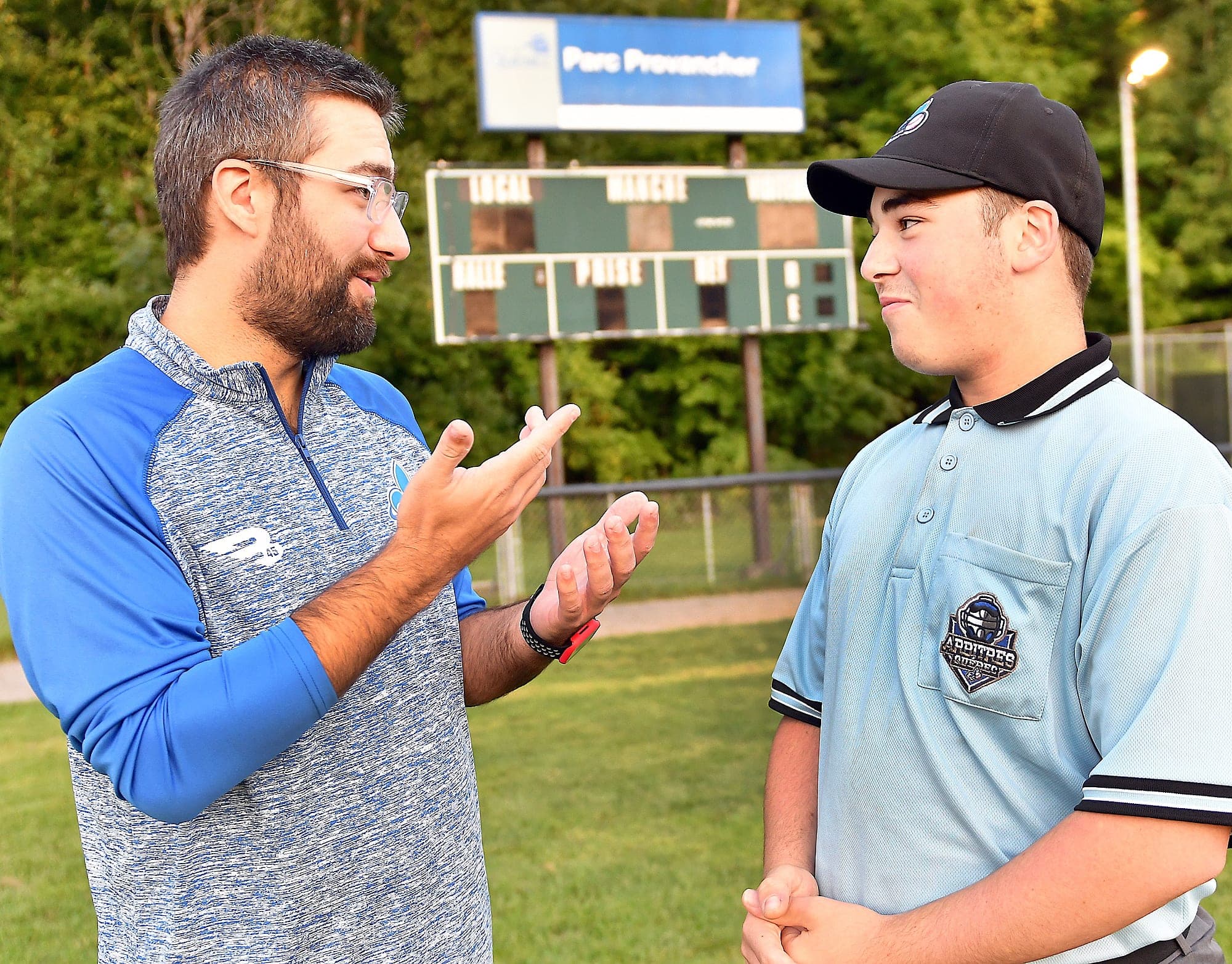 Jean-Nicolas Leroux, 16 ans, est arbitre au baseball depuis quatre ans. On le voit en discussion avec Mathieu Marcoux, arbitre en chef au baseball pour la région de Québec.