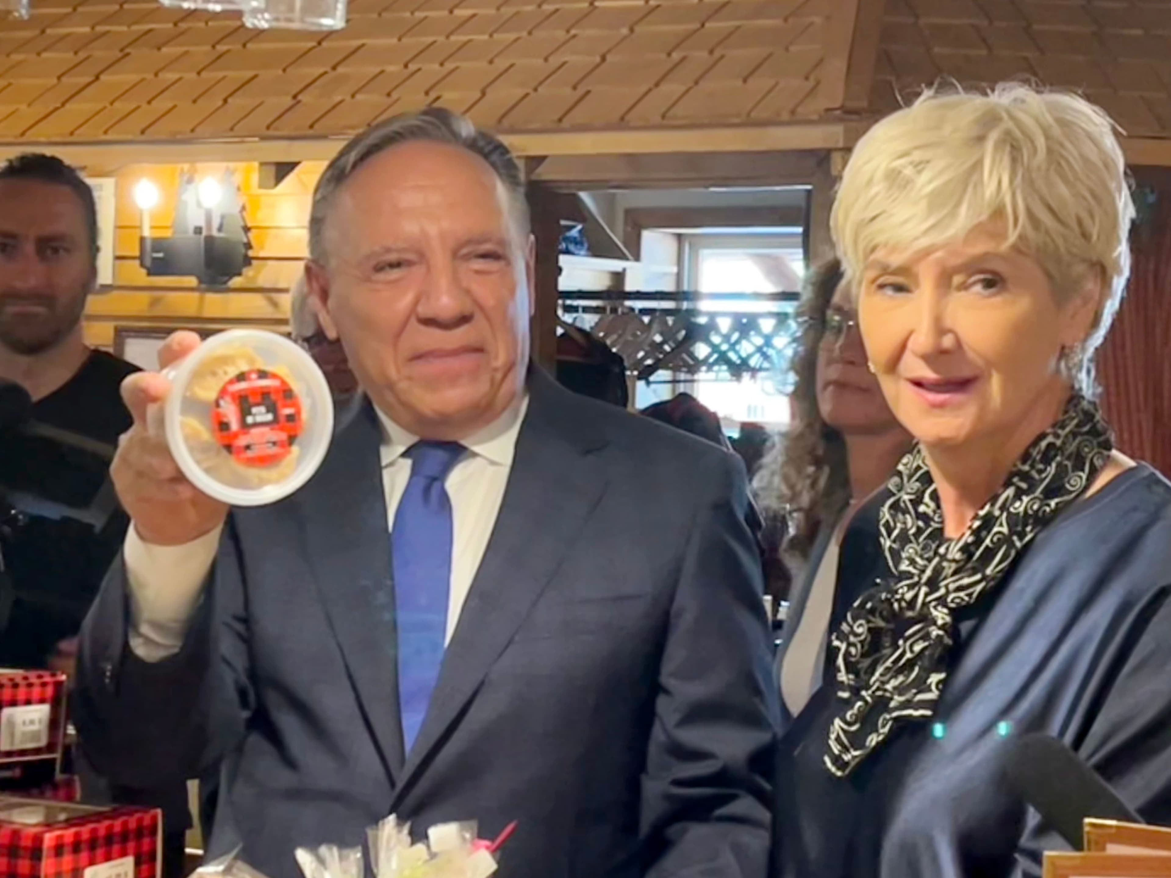 Le chef de la CAQ, François Legault, tient des pets de sœur dans un pot de plastique.
