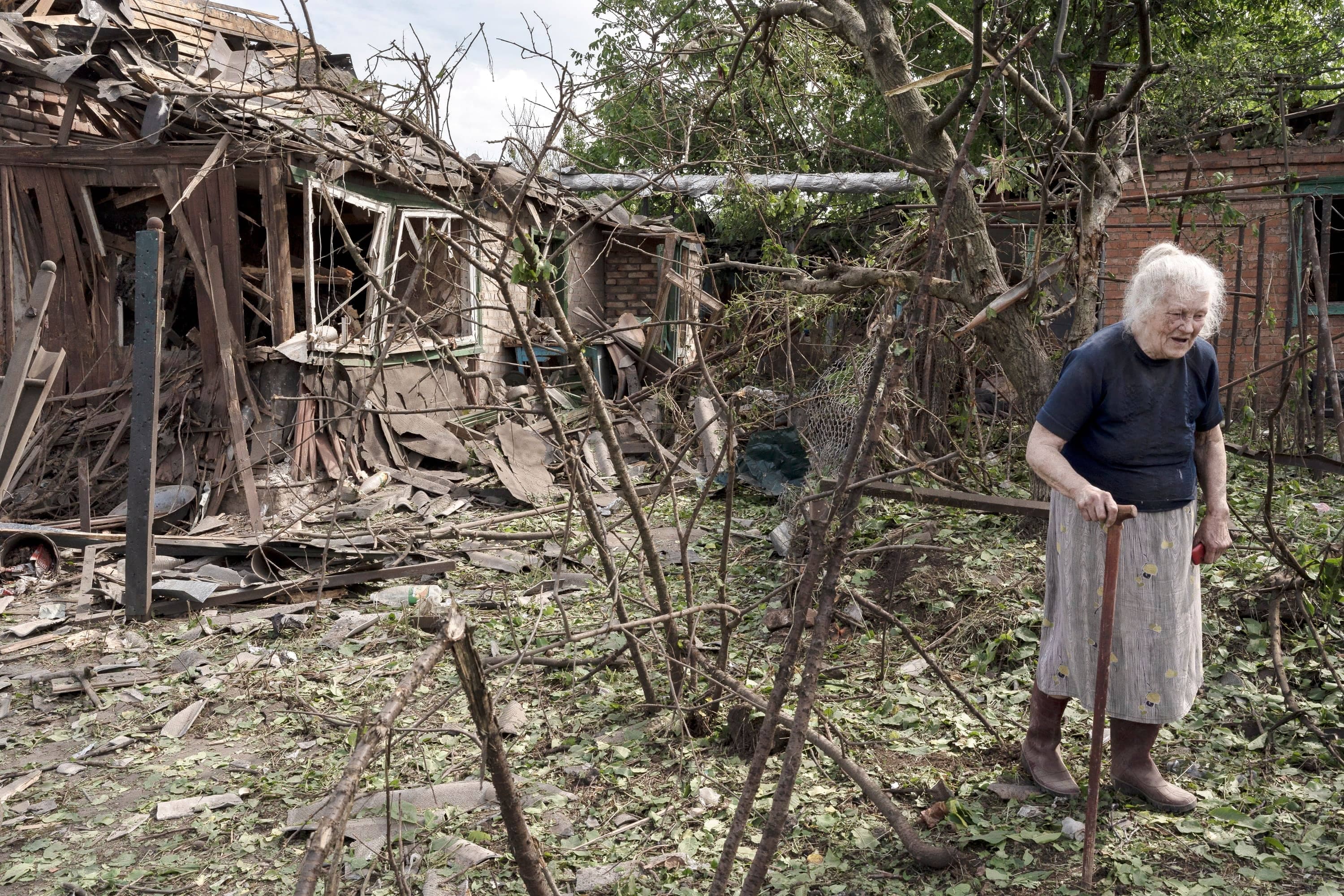 Helena Nikolaïvna s’éloigne de sa maison démolie à Droujkivka pendant une frappe nocturne dans le Donbass, en juin.
