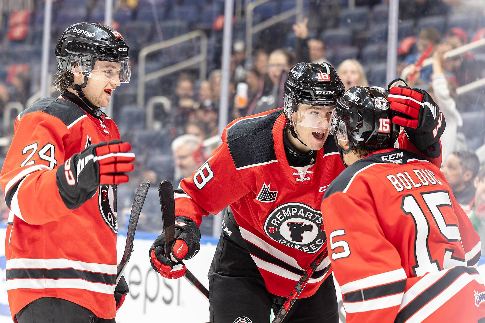 Les joueurs des Remparts Édouard Carrier (24), Charles Savoie (18) et Zachary Bolduc (15) célèbrent, samedi, après un des buts de Québec.