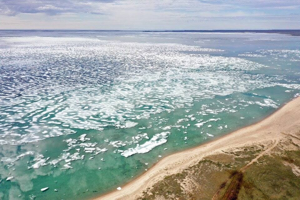 La fonte de la banquise vue du ciel au-dessus du passage du Nord-Ouest en juillet 2022 menace la sécurité du Canada et le mode de vie des Inuits comme ce Ranger, Wally Pauloosie de Taloyoak, au Nunavut, photographié ici en patrouille avec les Forces armées canadiennes près de la baie de Baffin.