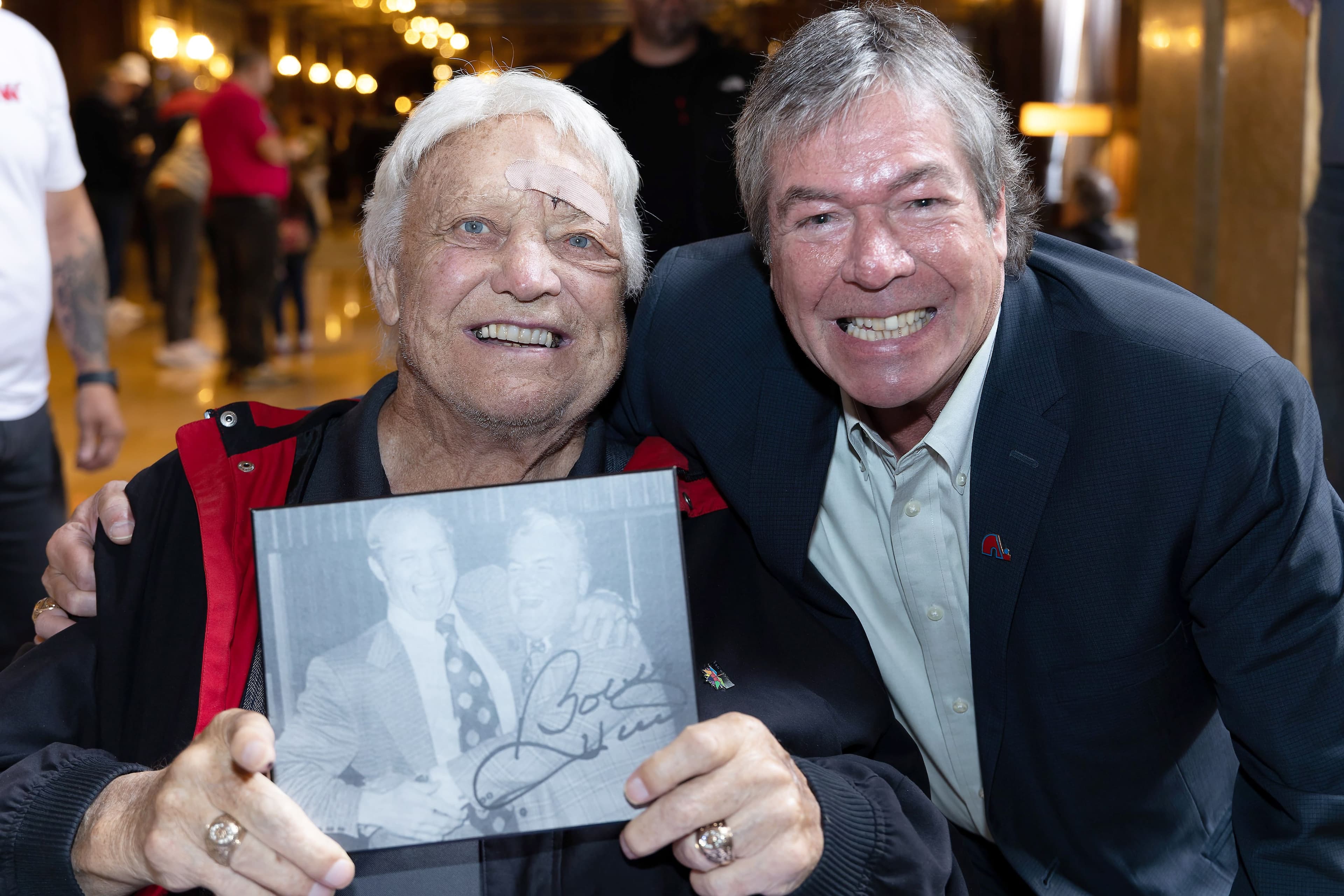 Bobby Hull avait une relation privilégiée avec la famille Racine de Québec. Sur la photo, l’ancien joueur vedette est en compagnie de Richard Racine, fils de l’un des fondateurs des Nordiques. Dans ses mains, Hull tient une image le montrant en compagnie de Paul Racine, à leur sortie du Banquet du match des étoiles de l’AMH en janvier 1973.