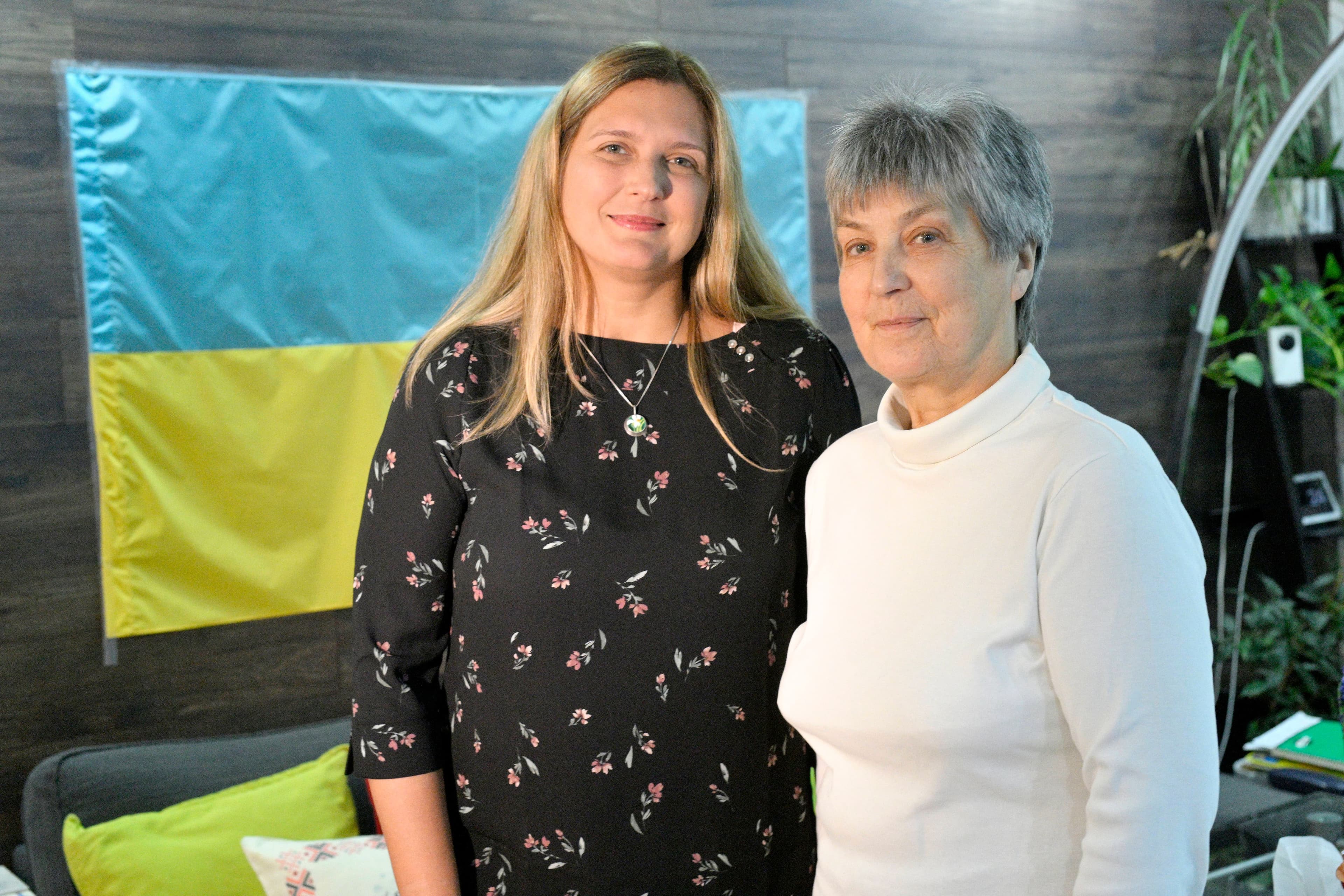Myroslava Polishchuk et sa mère, Natalka Poklad, posent devant l'immense drapeau ukrainien accroché dans son salon de Côte-Saint-Luc