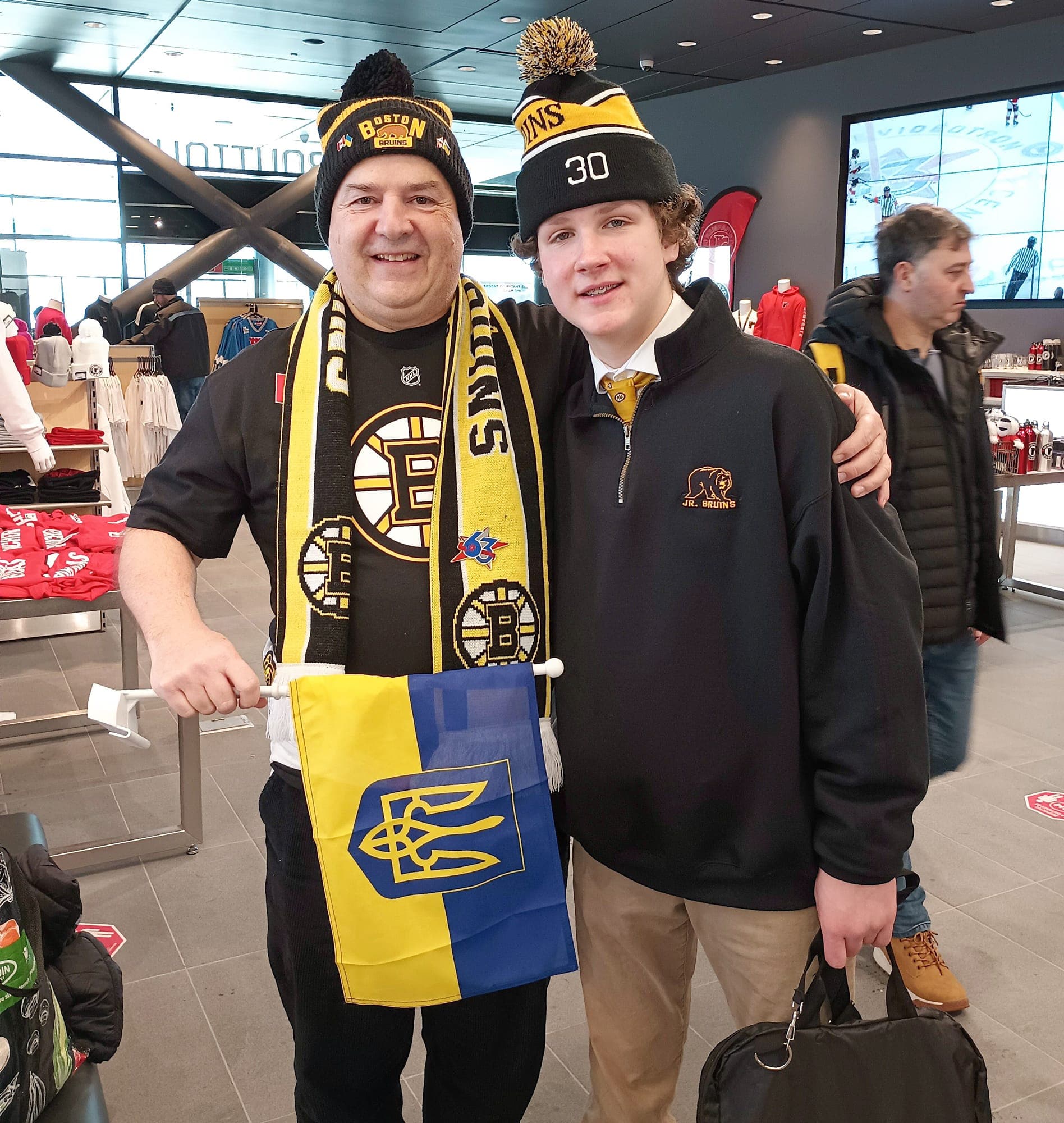 Daniel Bélanger, un résident de Montréal venu spécialement pour ce moment historique du tournoi, prend la pose avec le gardien des petits Bruins, James Borccuzzi.