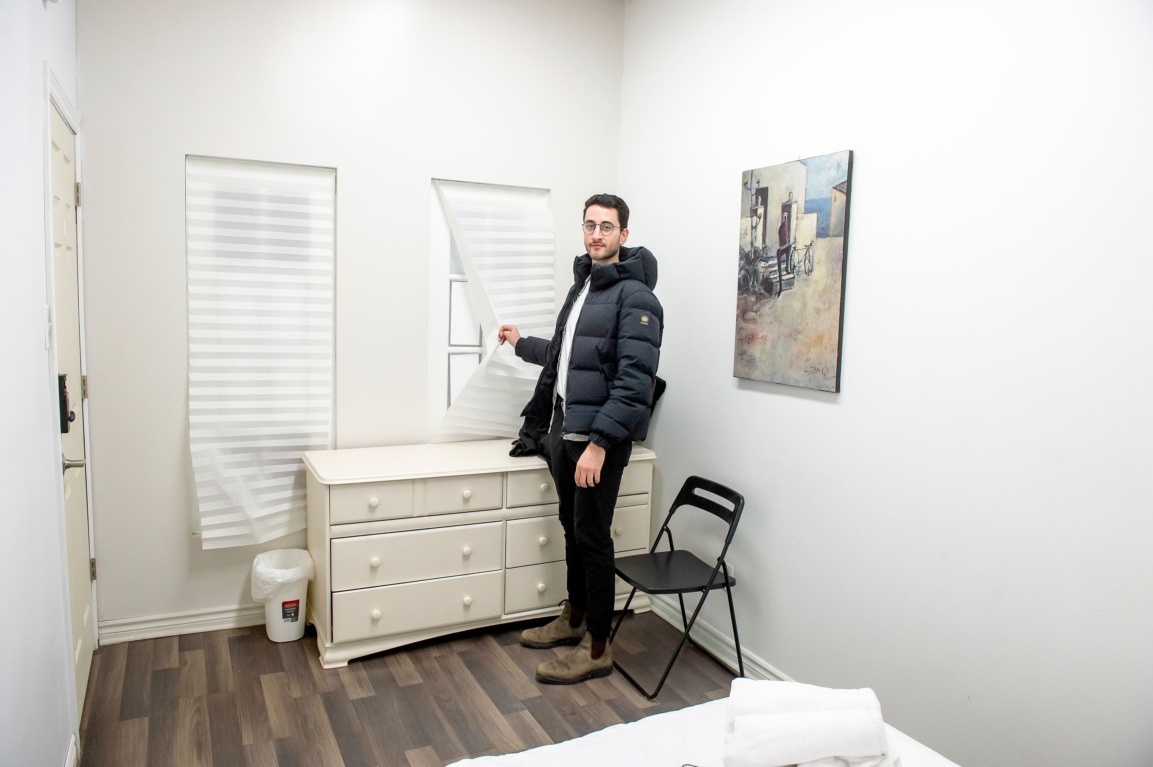Notre journaliste montrant une fausse fenêtre dans la chambre louée dans l'auberge jeunesse au 402 rue Notre-Dame Est.