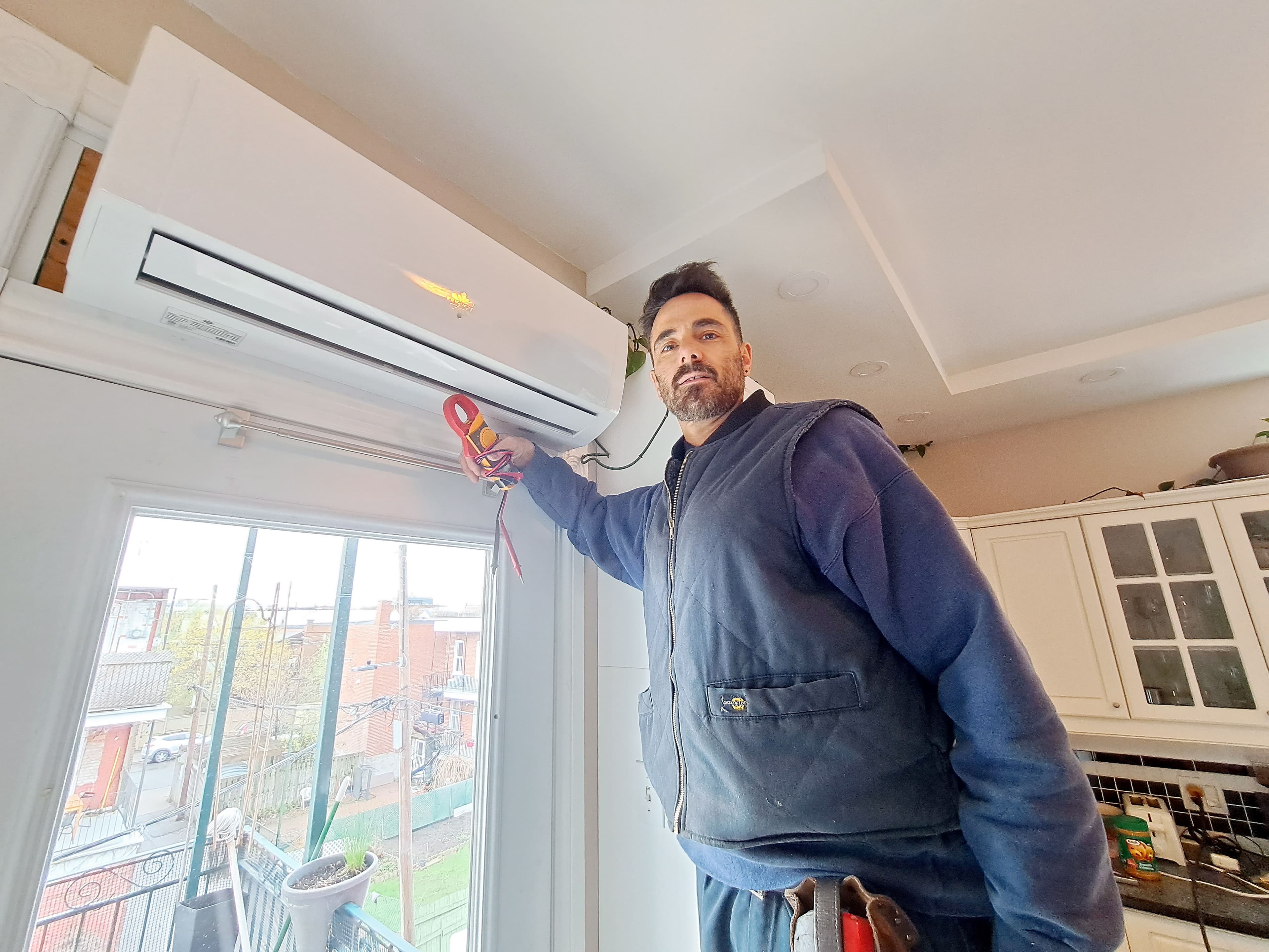 L’entrepreneur Patrick Bourassa installant un modèle intérieur d’une thermopompe dans un appartement du quartier Rosemont, à Montréal, le 3 mai dernier.