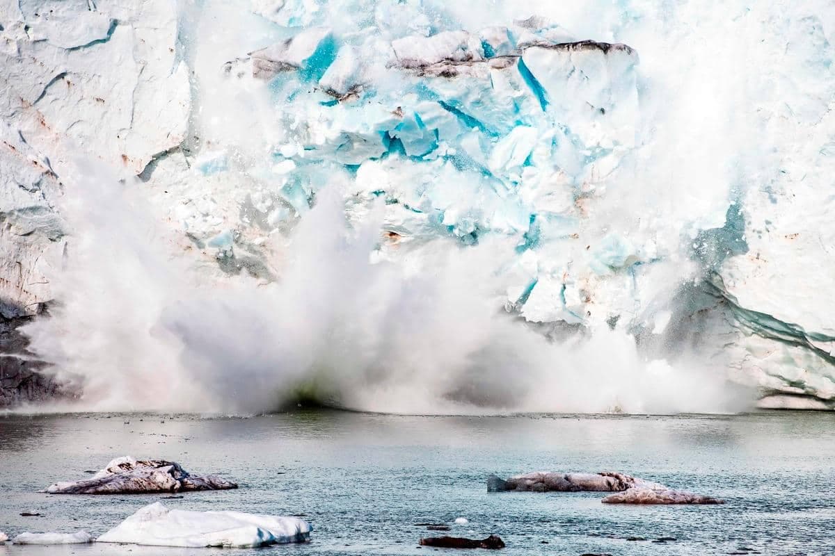 Cette photo d'archives prise le 17 août 2019 montre un iceberg vêlant avec une masse de glace qui se détache du glacier Apusiajik, près de Kulusuk (également orthographié Qulusuk), une colonie de la municipalité de Sermersooq située sur l'île du même nom au sud-est rive du Groenland. - La fonte de la calotte glaciaire du Groenland est allée si loin qu'elle est désormais irréversible, les chutes de neige ne pouvant plus compenser la perte de glace même si le réchauffement climatique devait s'arrêter aujourd'hui, selon les chercheurs.