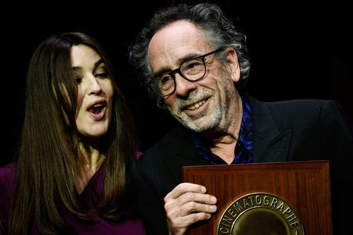 Tim Burton réagit alors qu'il reçoit le Prix Lumière de l'actrice italienne Monica Bellucci lors de la cérémonie de remise des prix de la 14e édition du Festival Lumière à Lyon, France, le 21 octobre 2022. (Photo de Jeff PACHOUD / AFP)